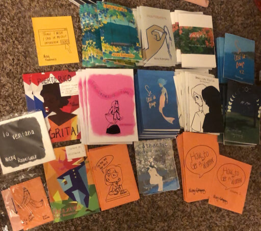 An array of different colorful zines arranged on the floor.