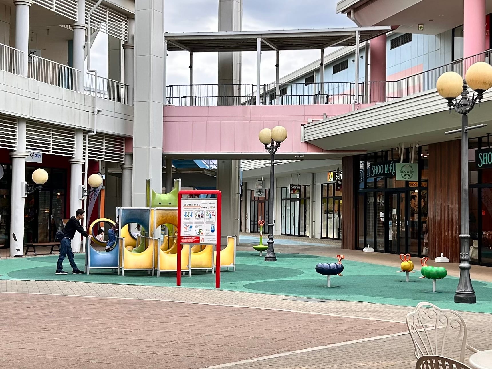 緑の舗装エリアにある低めの遊具とスプリング遊具