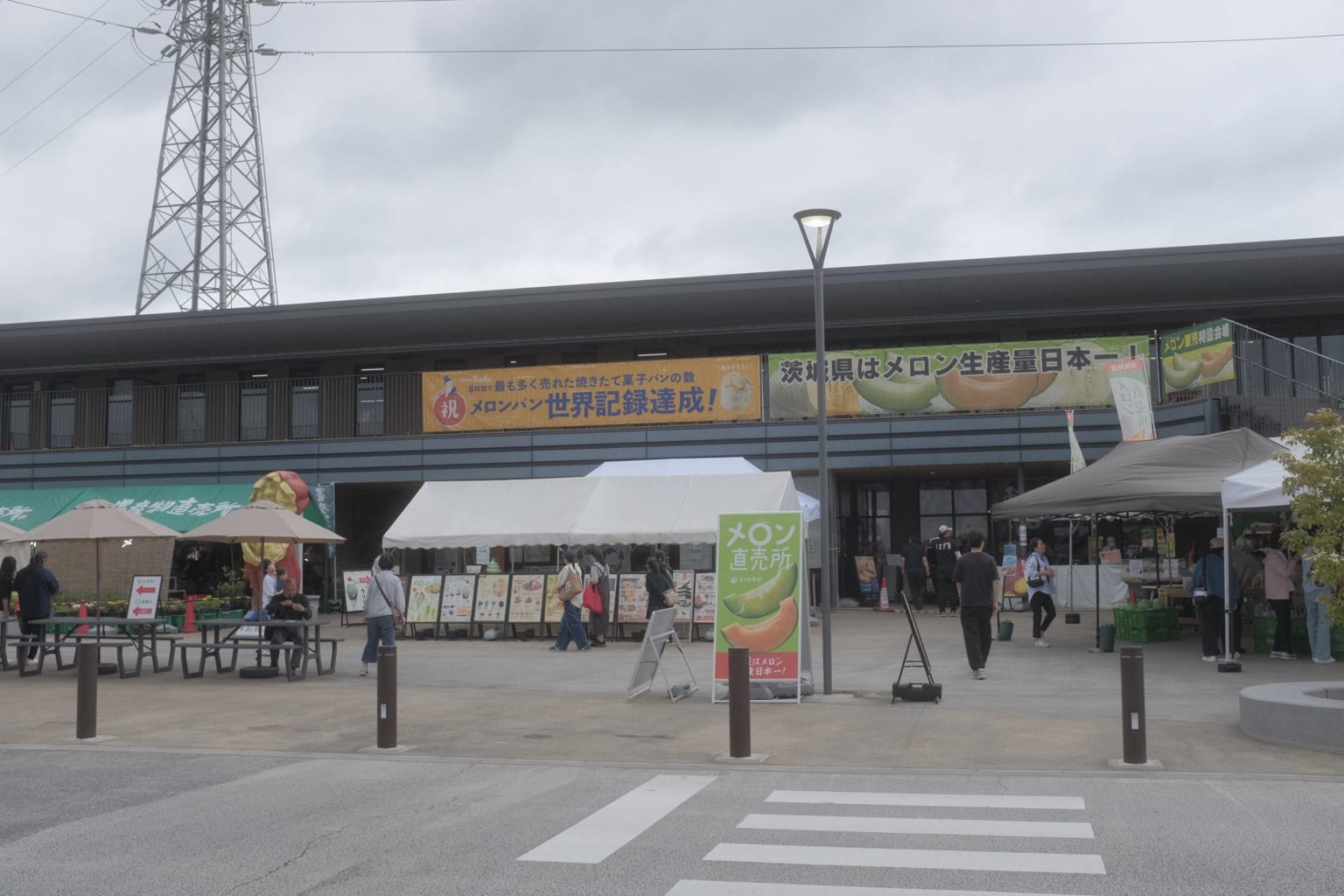 メロン直売所の看板とテントが並ぶ道の駅常総の外観