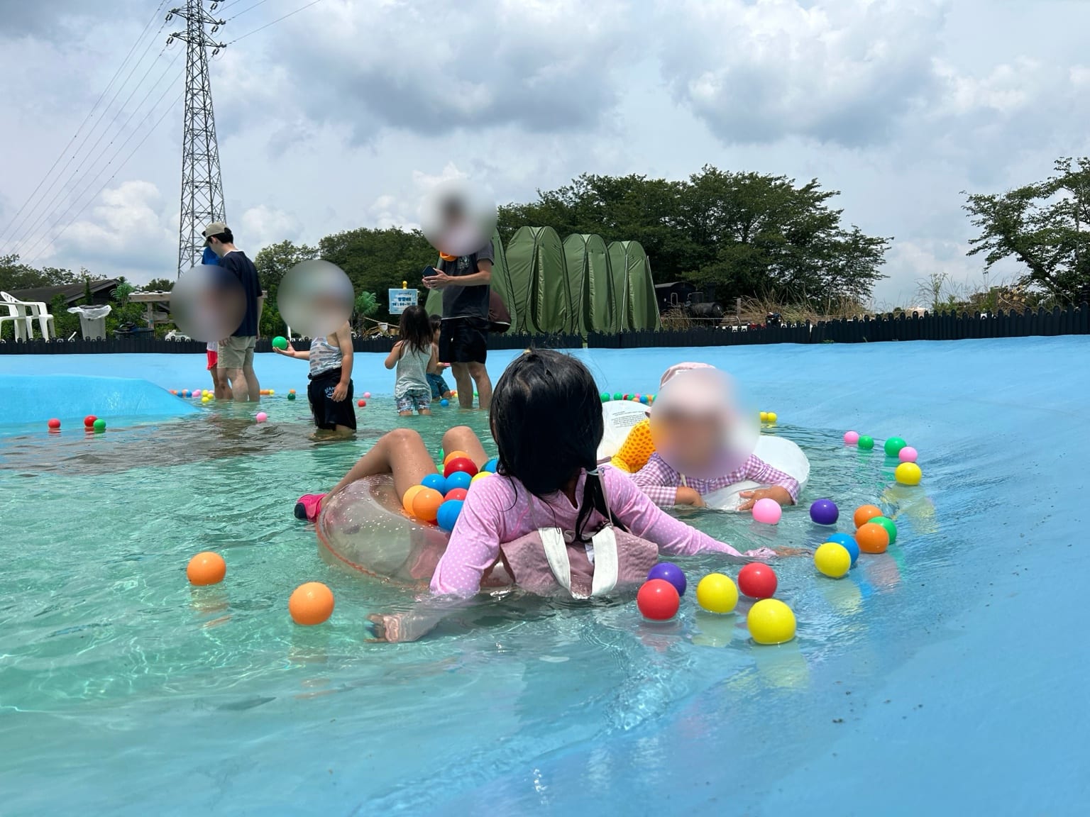 浮き輪に乗ってカラーボールを集める子どもたち