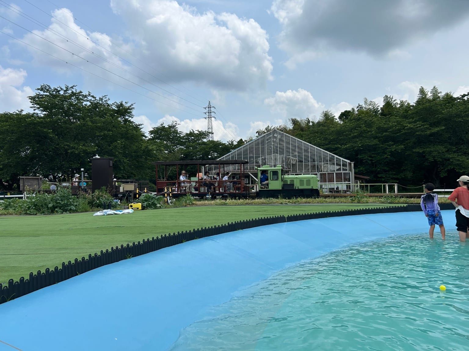 成田ゆめ牧場のじゃぶじゃぶ池の奥を走る緑の汽車