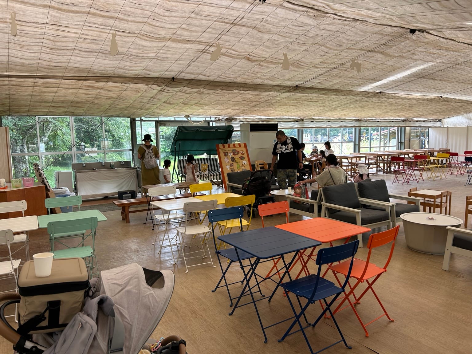 カラフルなテーブルとイスが並ぶ成田ゆめ牧場の屋内休憩スペース