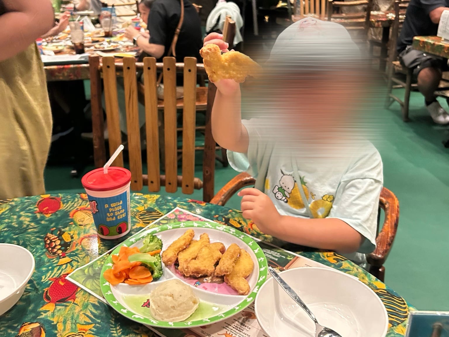 チキンを手に持って食べる子どもとボリュームのあるキッズプレート