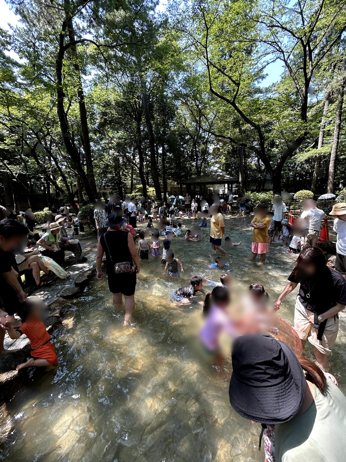 水の流れる石造りの滑り台を滑る子ども