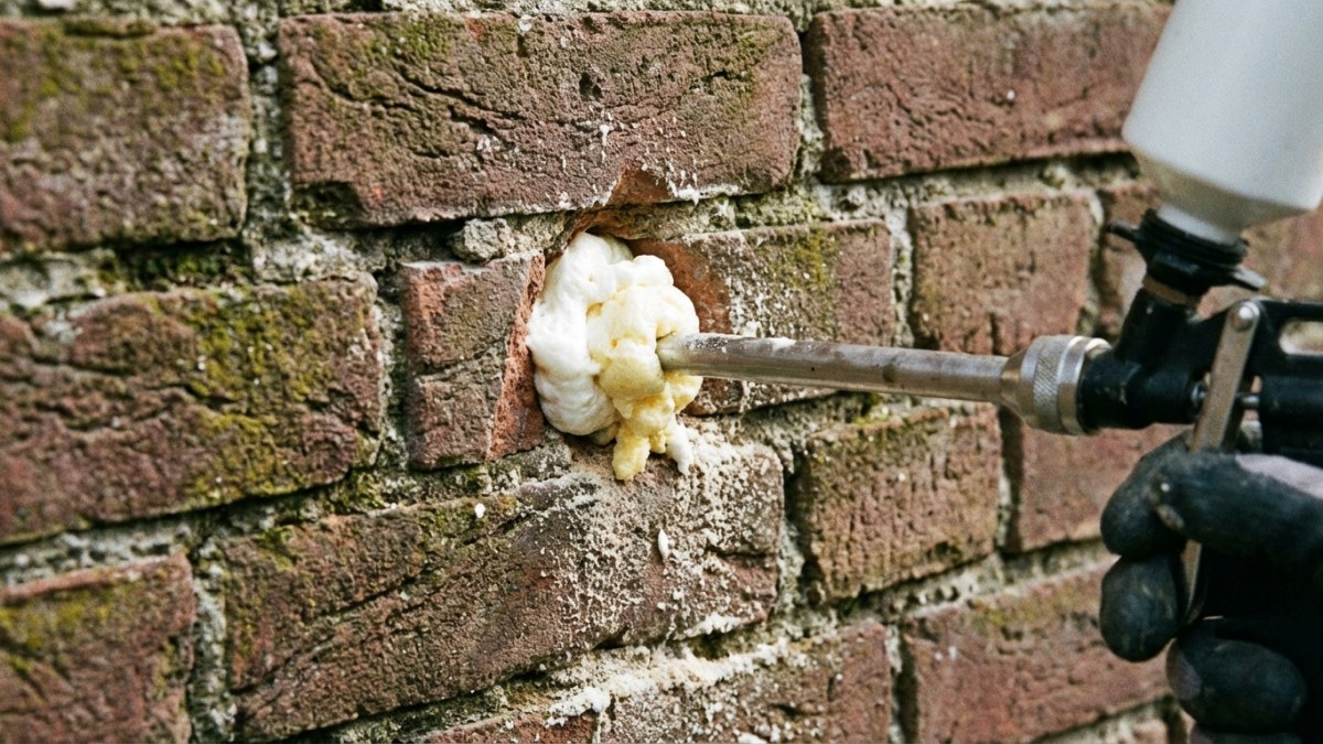Isolatiemateriaal wordt in spouwmuur geïnjecteerd