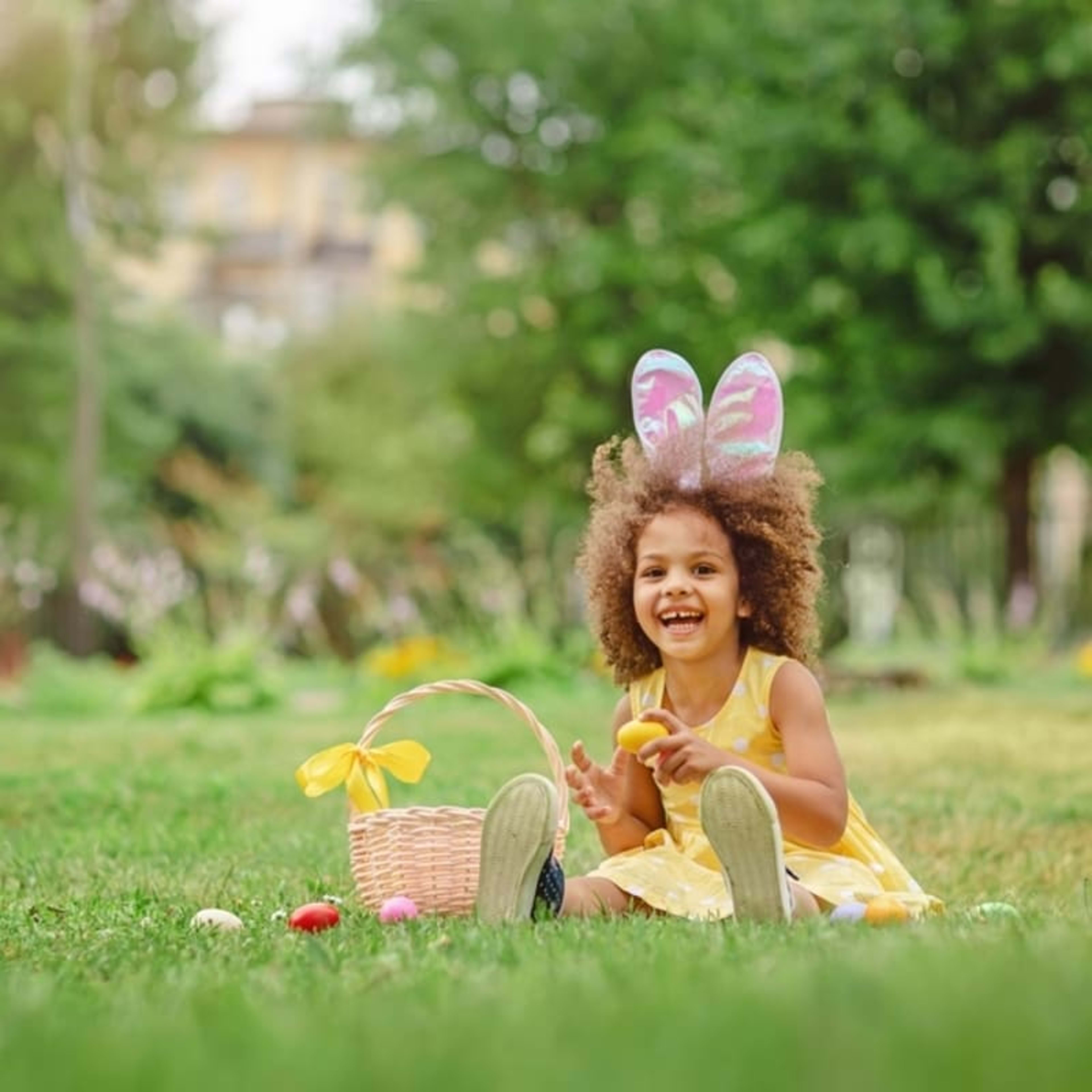 Little girl wearing bunny ears on a traditional Easter egg hunt.