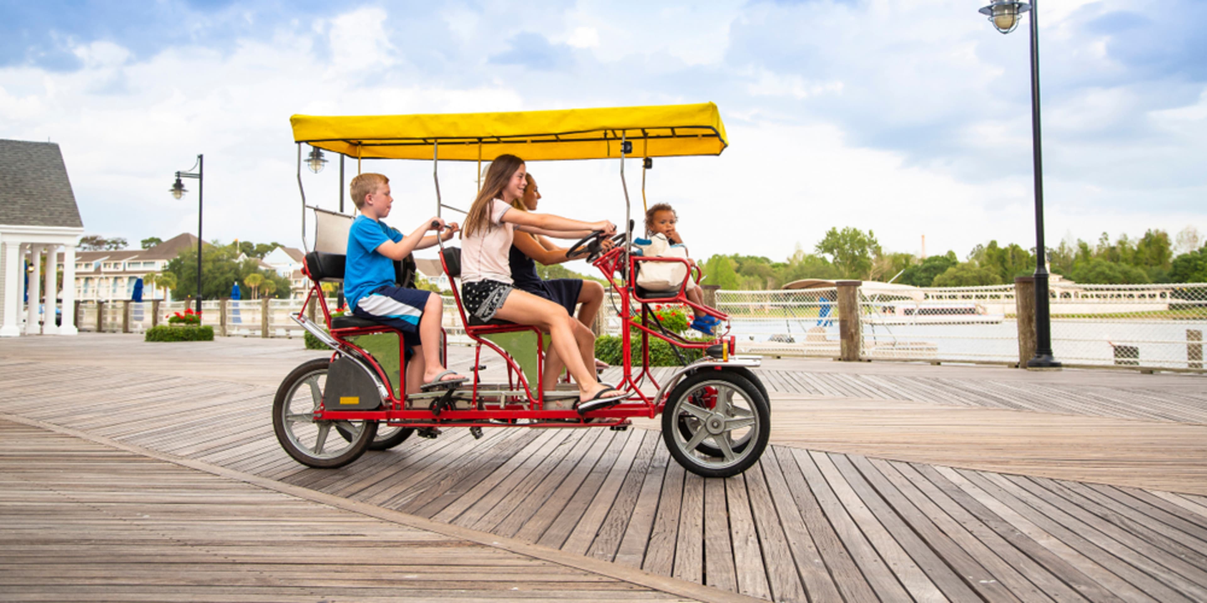 Familia en una bici surrey por un paseo marítimo, Orlando. Moverse por Orlando.