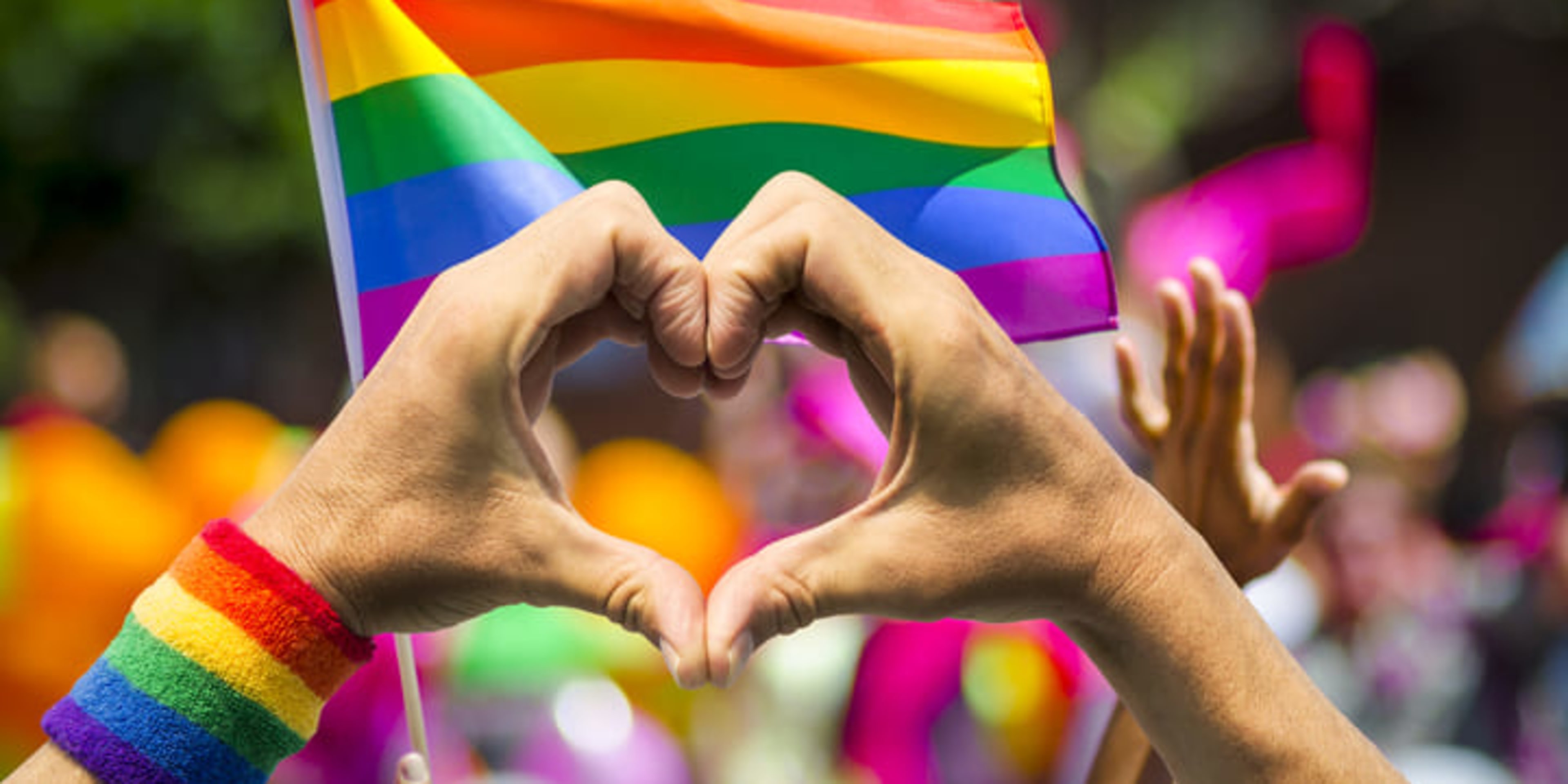 Mãos formando um coração no festival do Orgulho LGBTQ+
