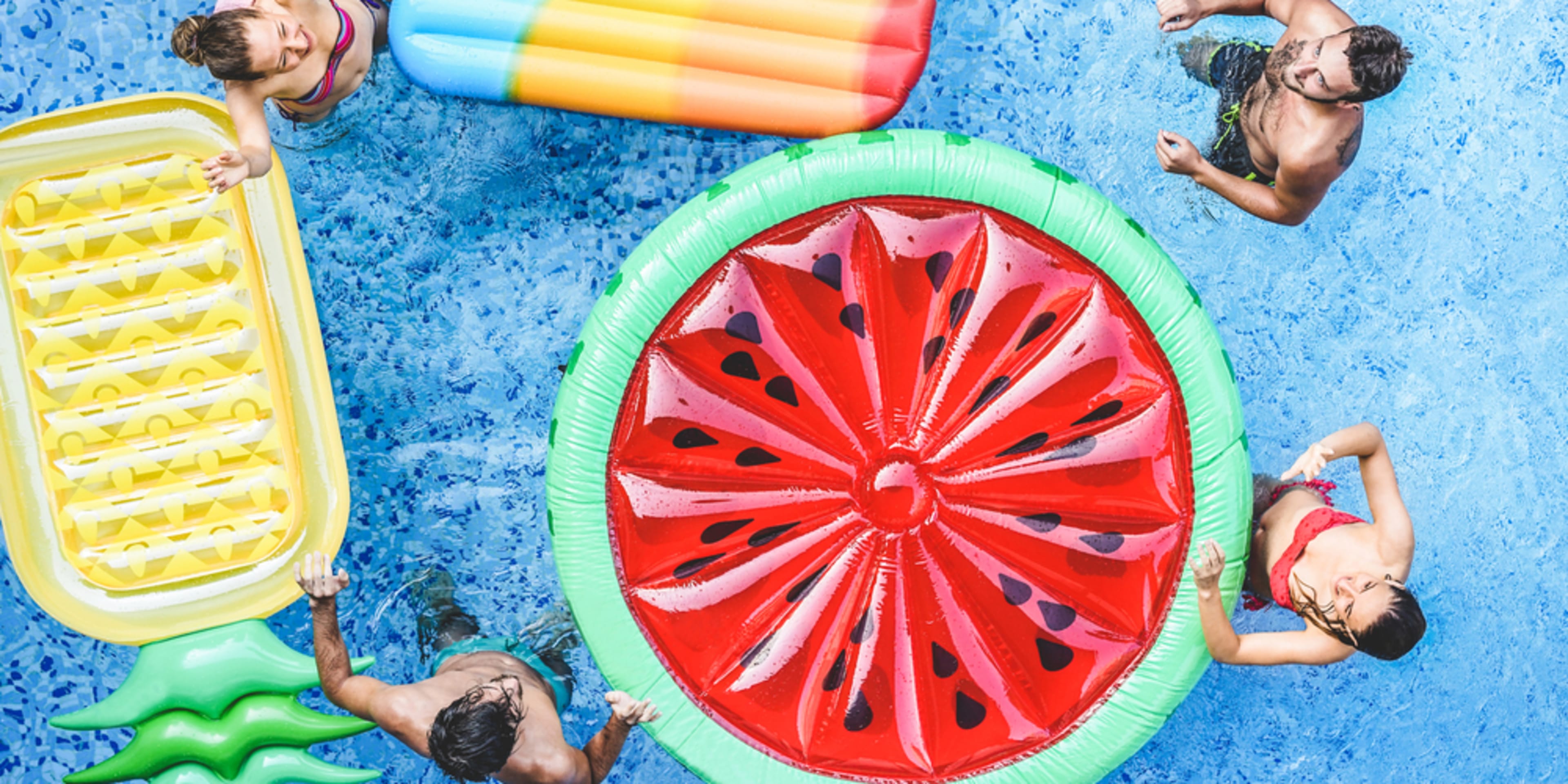 Gente con flotadores de colores en la piscina. Planes para celebrar tu cumpleaños en Miami.