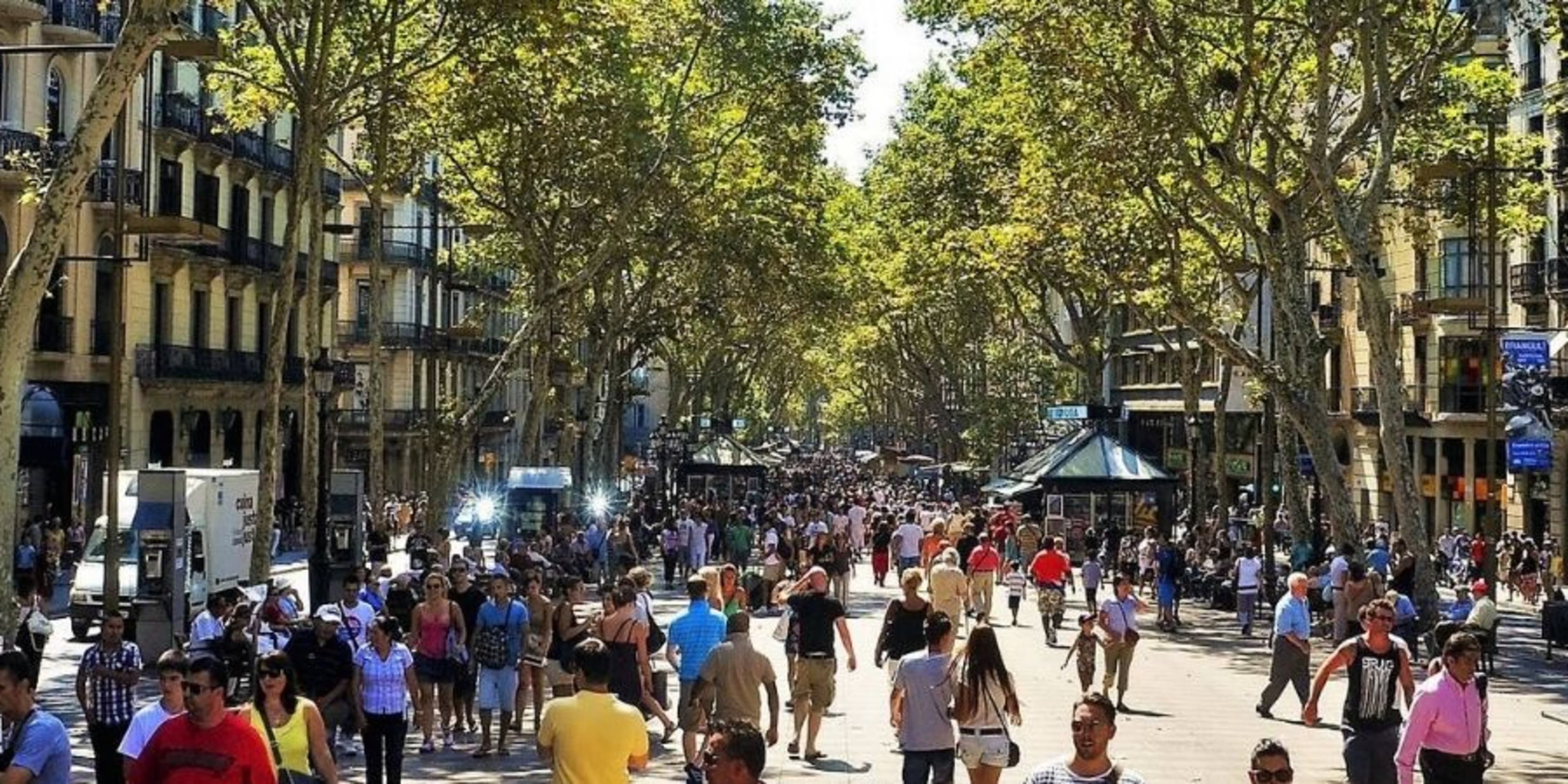 Wide view of La Rambla Barcelona - tree lined street, shoppers and stalls