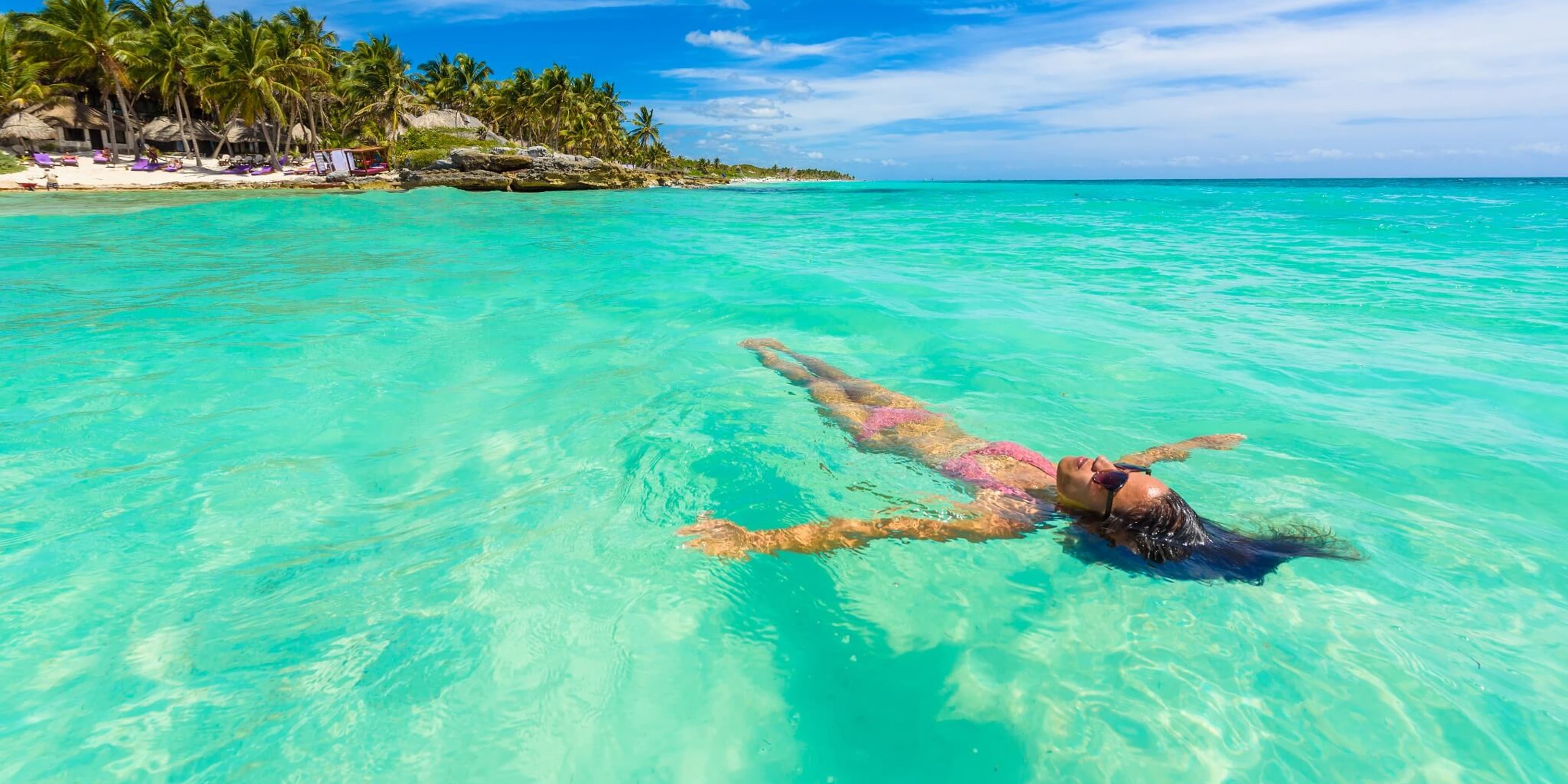 A woman floats in the shallows in Cancun