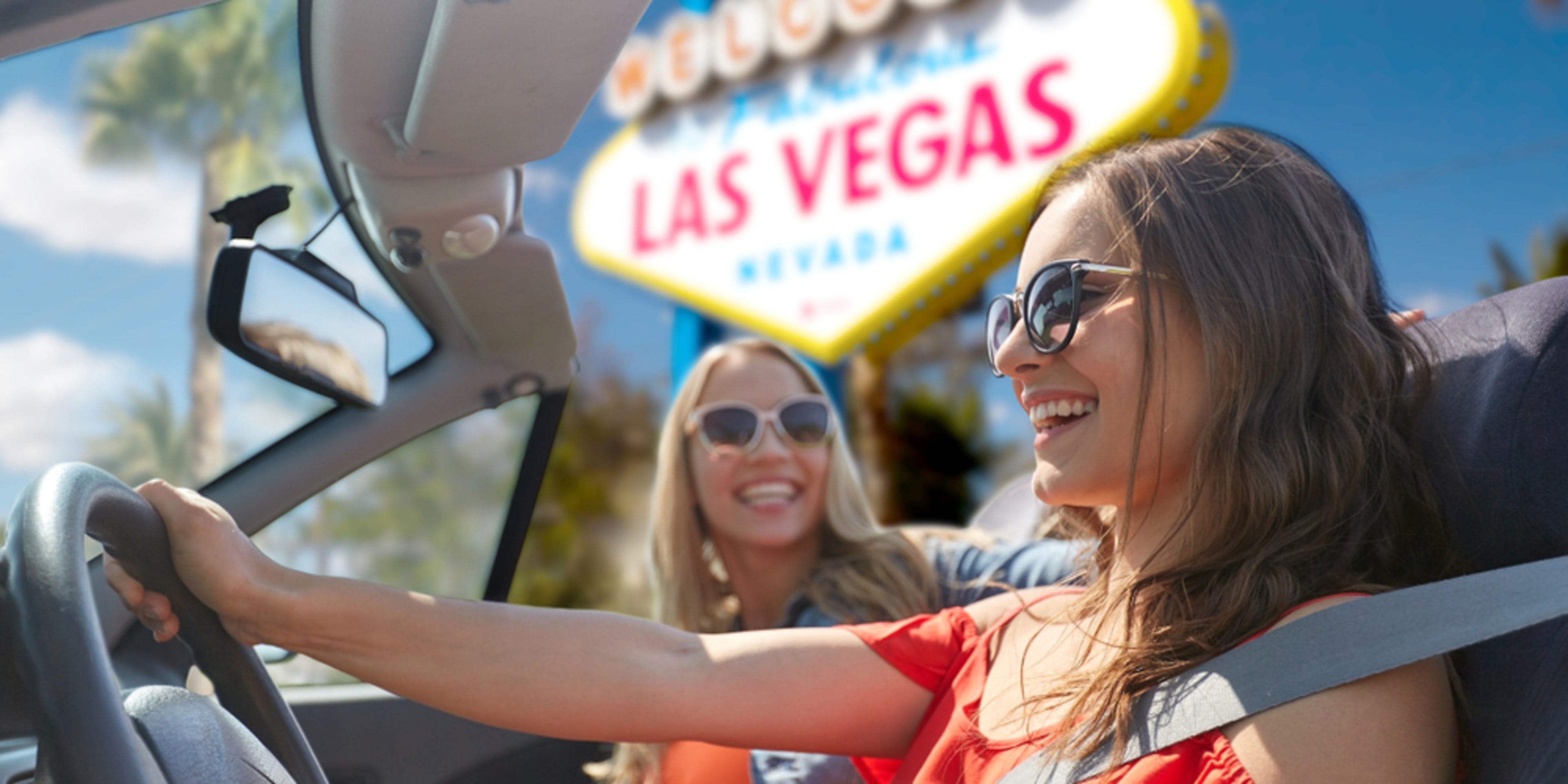 Mujeres en coche junto al cartel de Las Vegas. Cómo llegar a Las Vegas desde el aeropuerto.