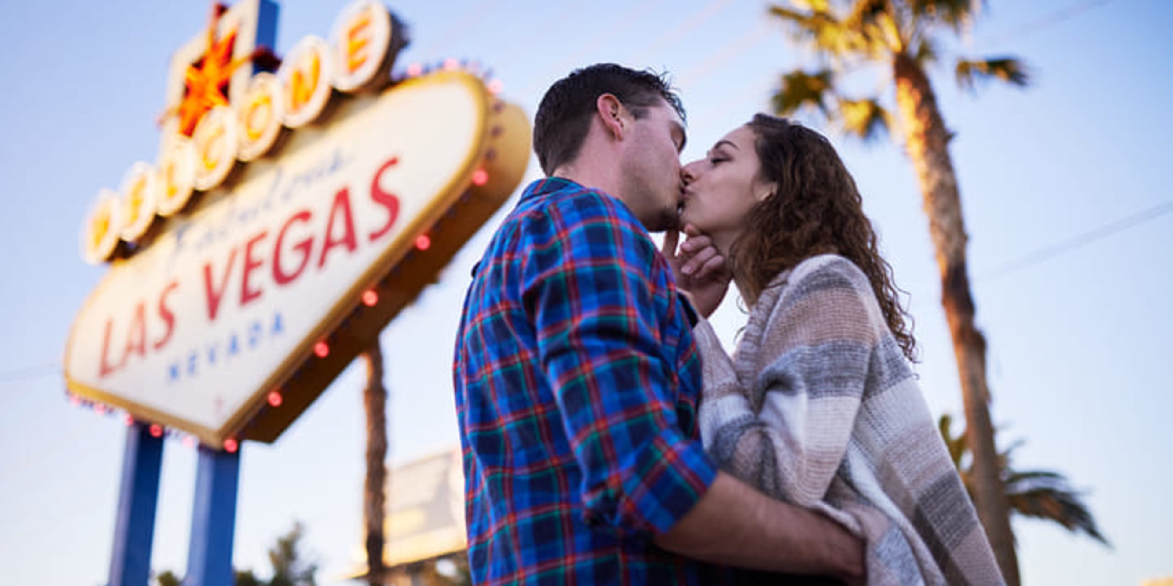 Couple kissing in front of the 'Welcome to Fabulous Las Vegas' sign