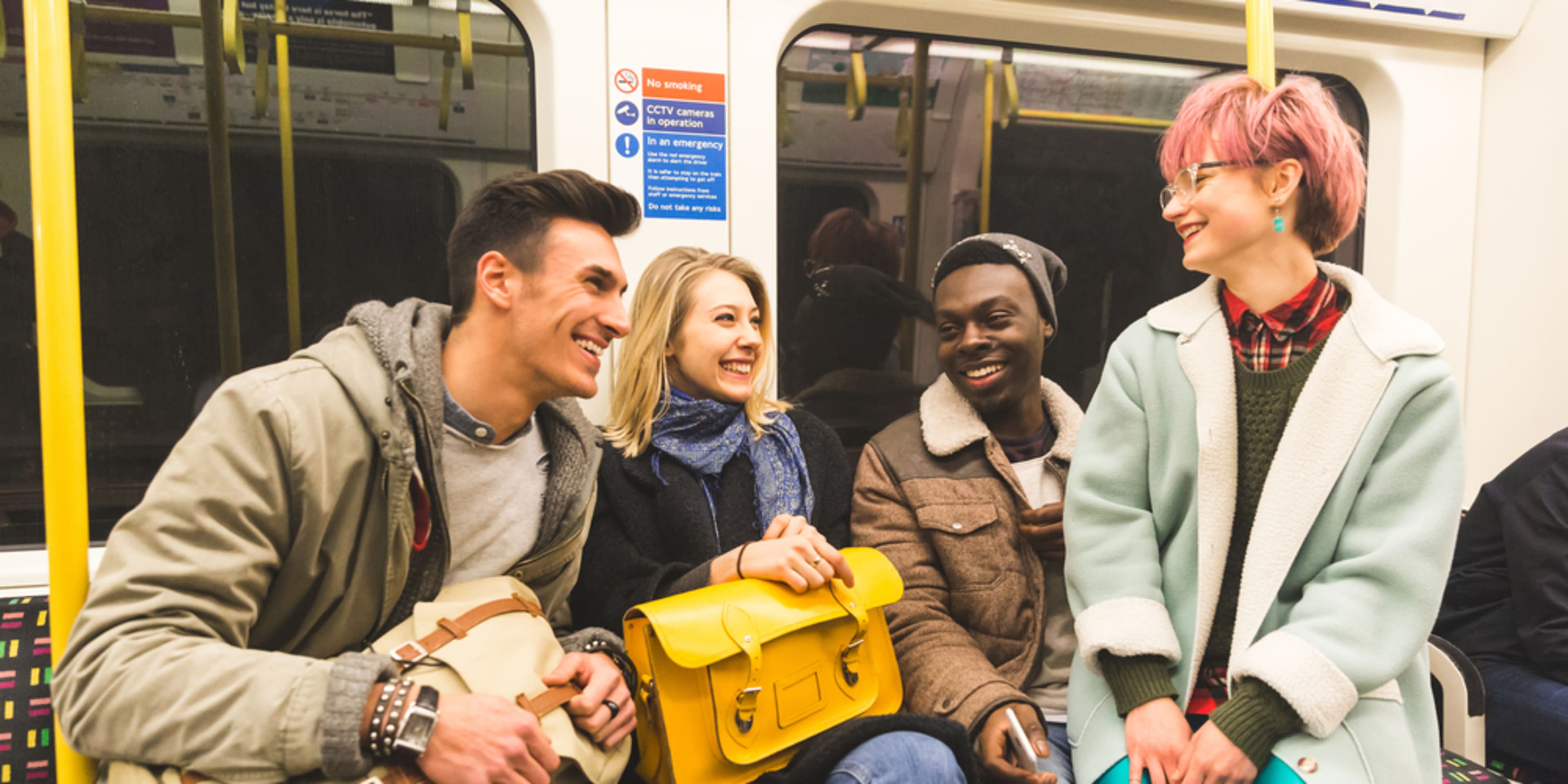 Grupo de jóvenes en el metro de Londres. Medios de transporte en Londres.