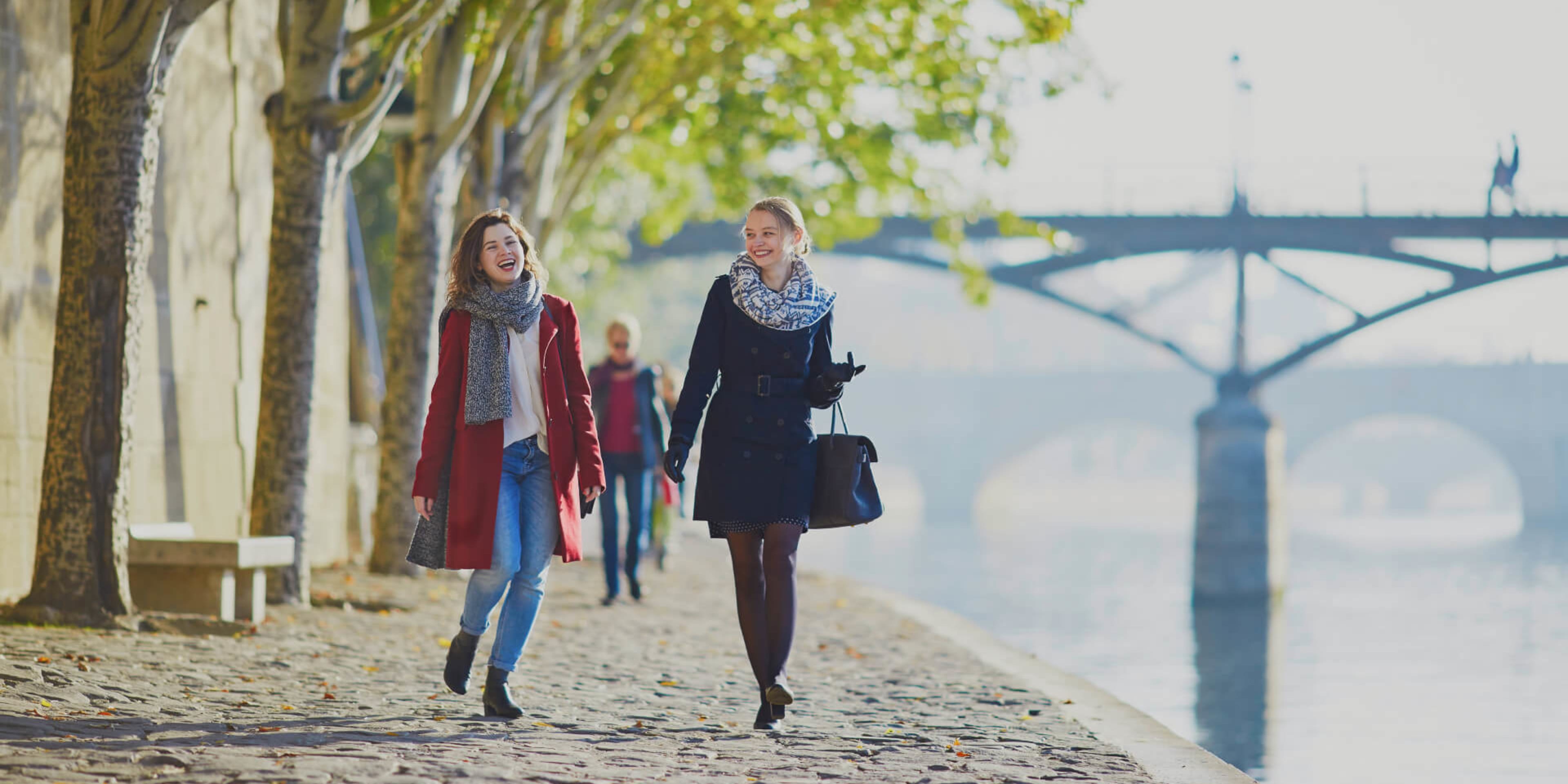 Two women enjoy a walk along the banks of the Seine