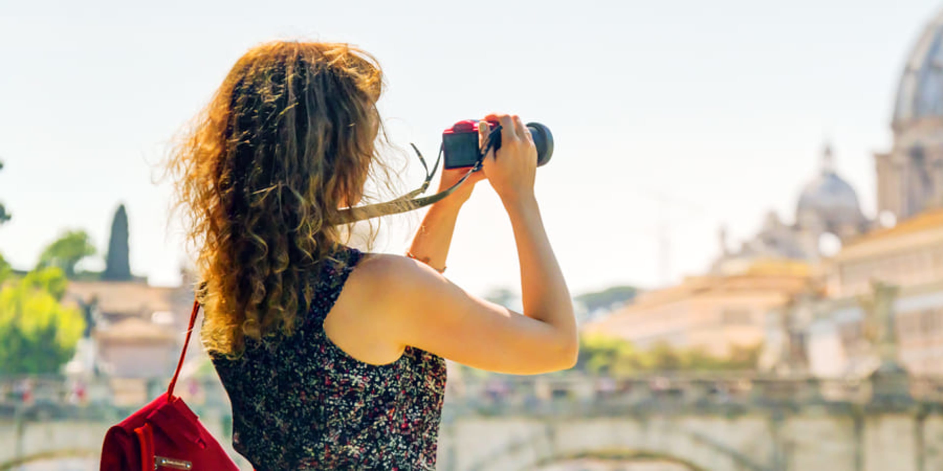 Woman photographing St Peter's Basilica in Rome
