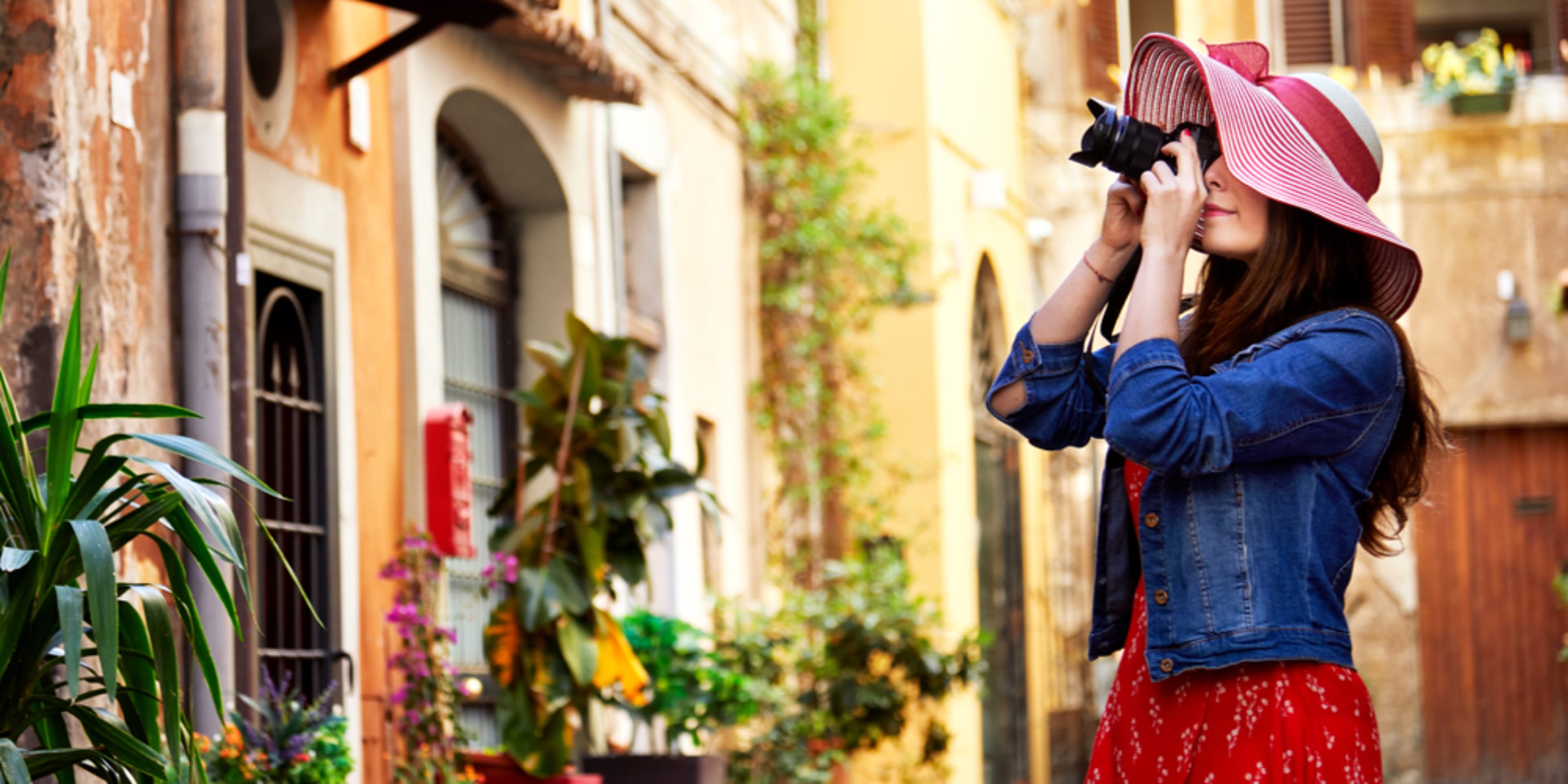 Une femme prend une photo d'une façade d'une maison à Rome