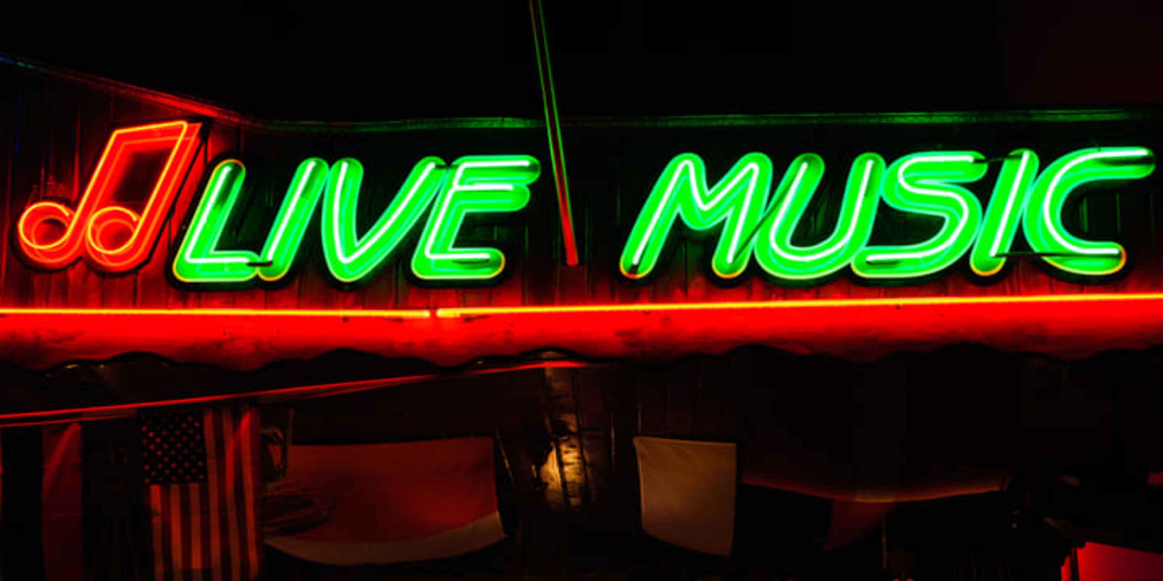 Insegna al neon che pubblicizza musica dal vivo con luci verdi e rosse.