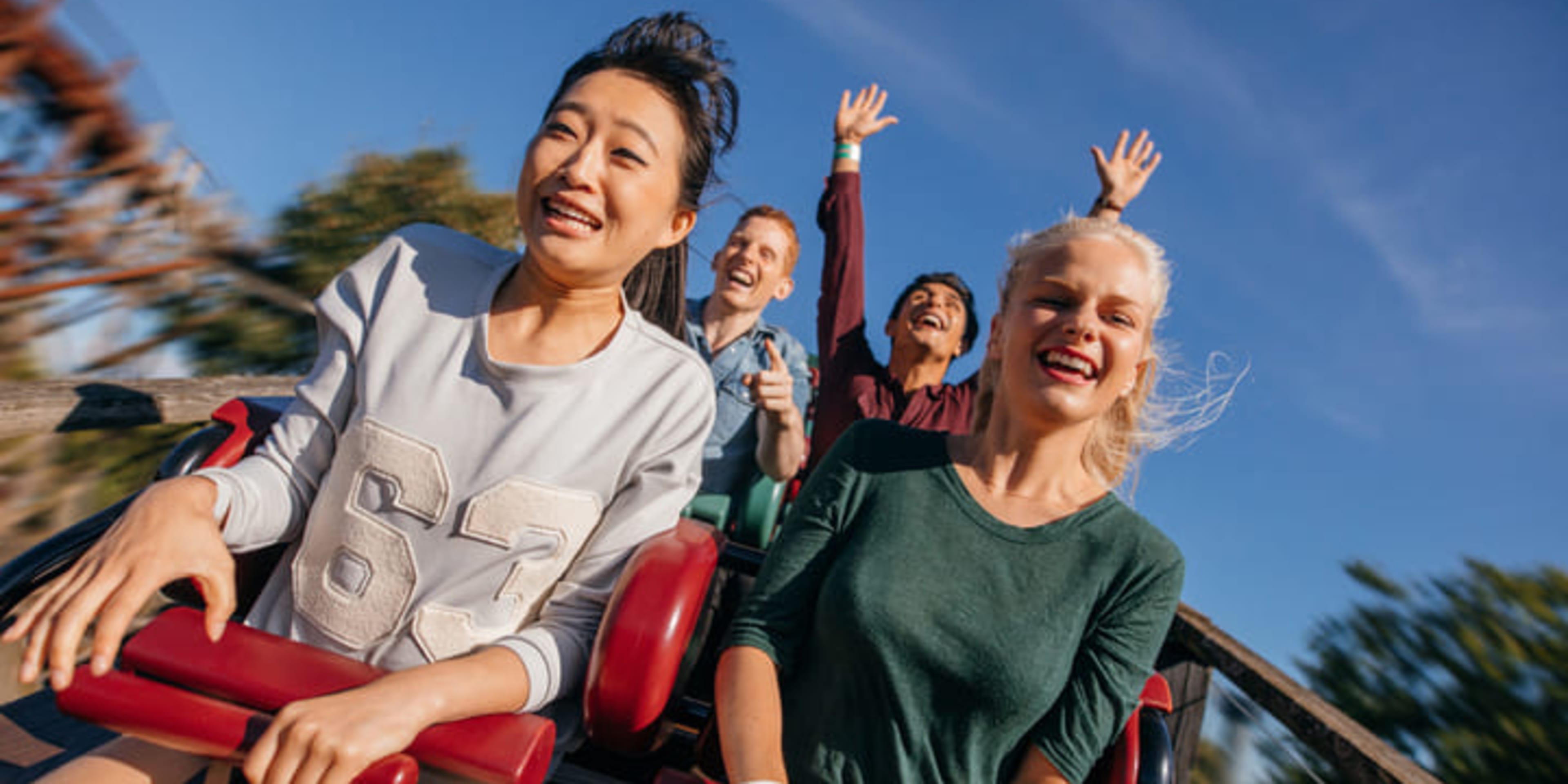 正在雲霄飛車上盡情玩樂的朋友們。