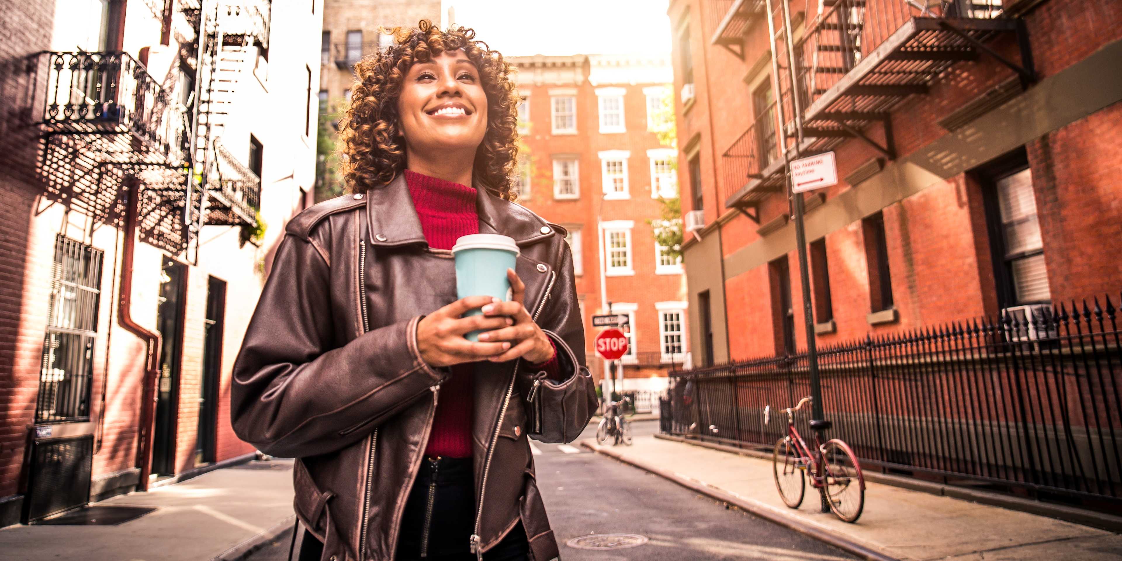 woman drinking coffee on a stroll in greenwich village, nyc