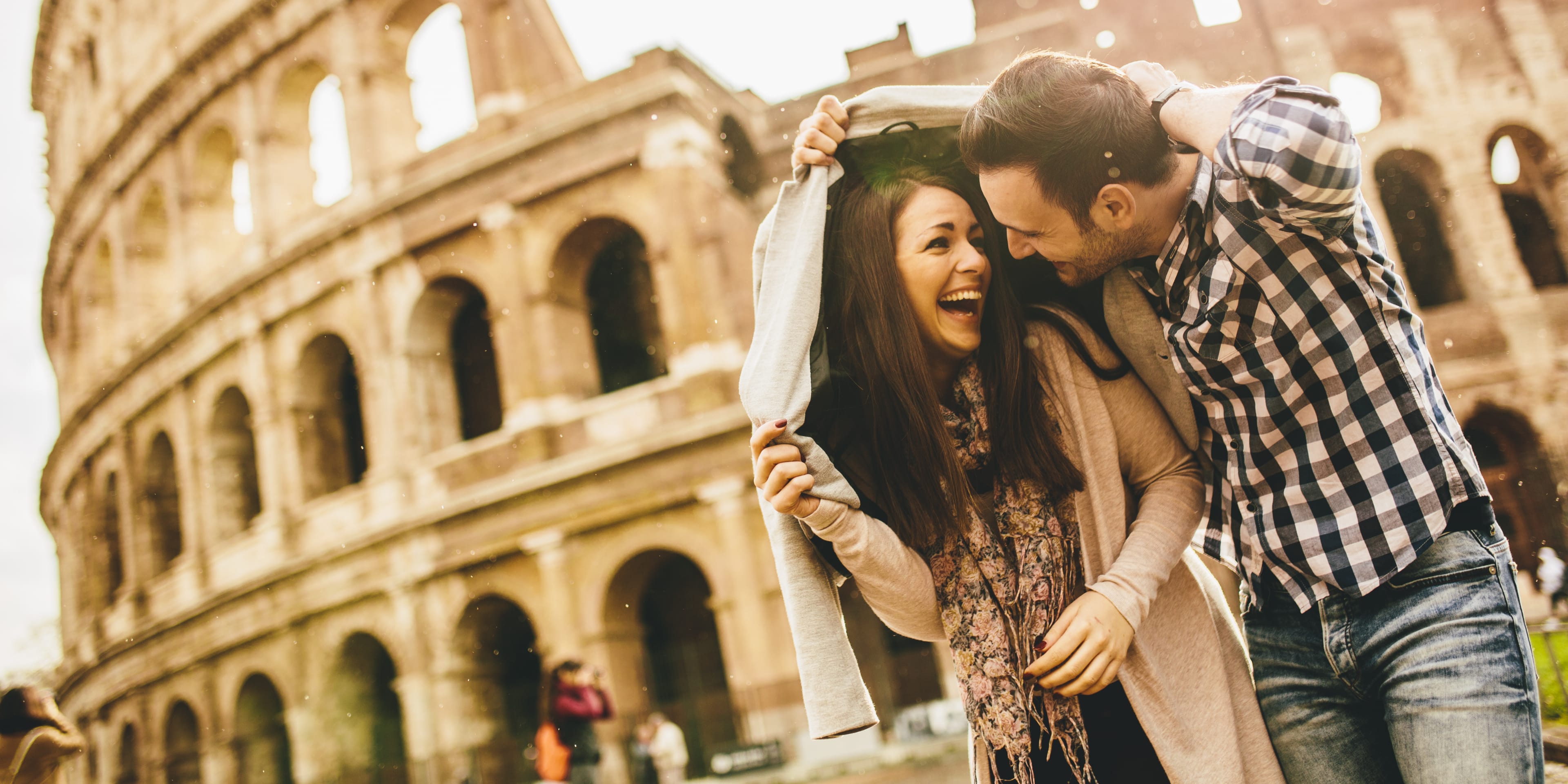 Couple with umbrellas in front of St Peter's Basilica in Rome