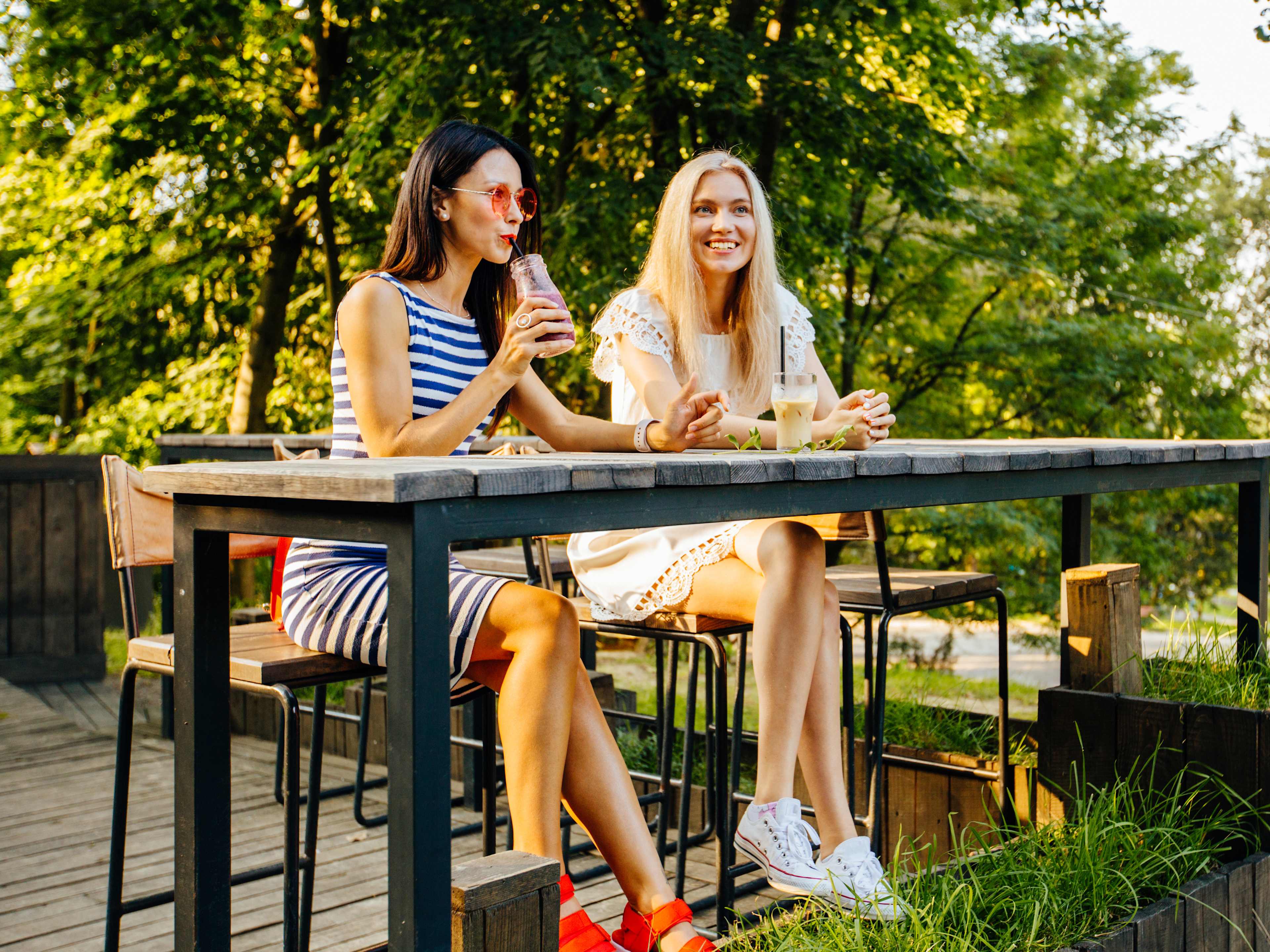 two friends enjoying a drink in the sun in stockholm