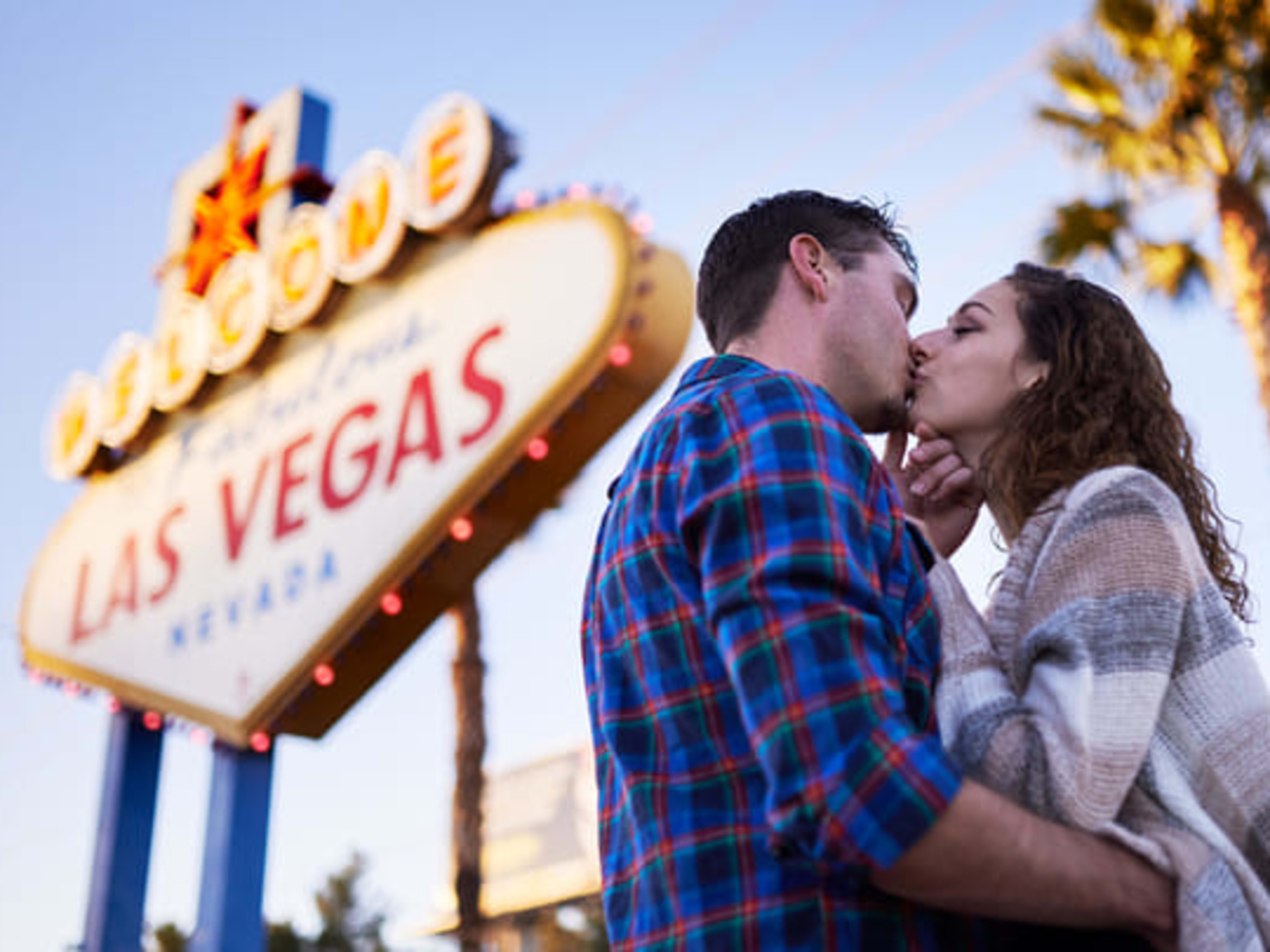 Couple kissing in front of the 'Welcome to Fabulous Las Vegas' sign