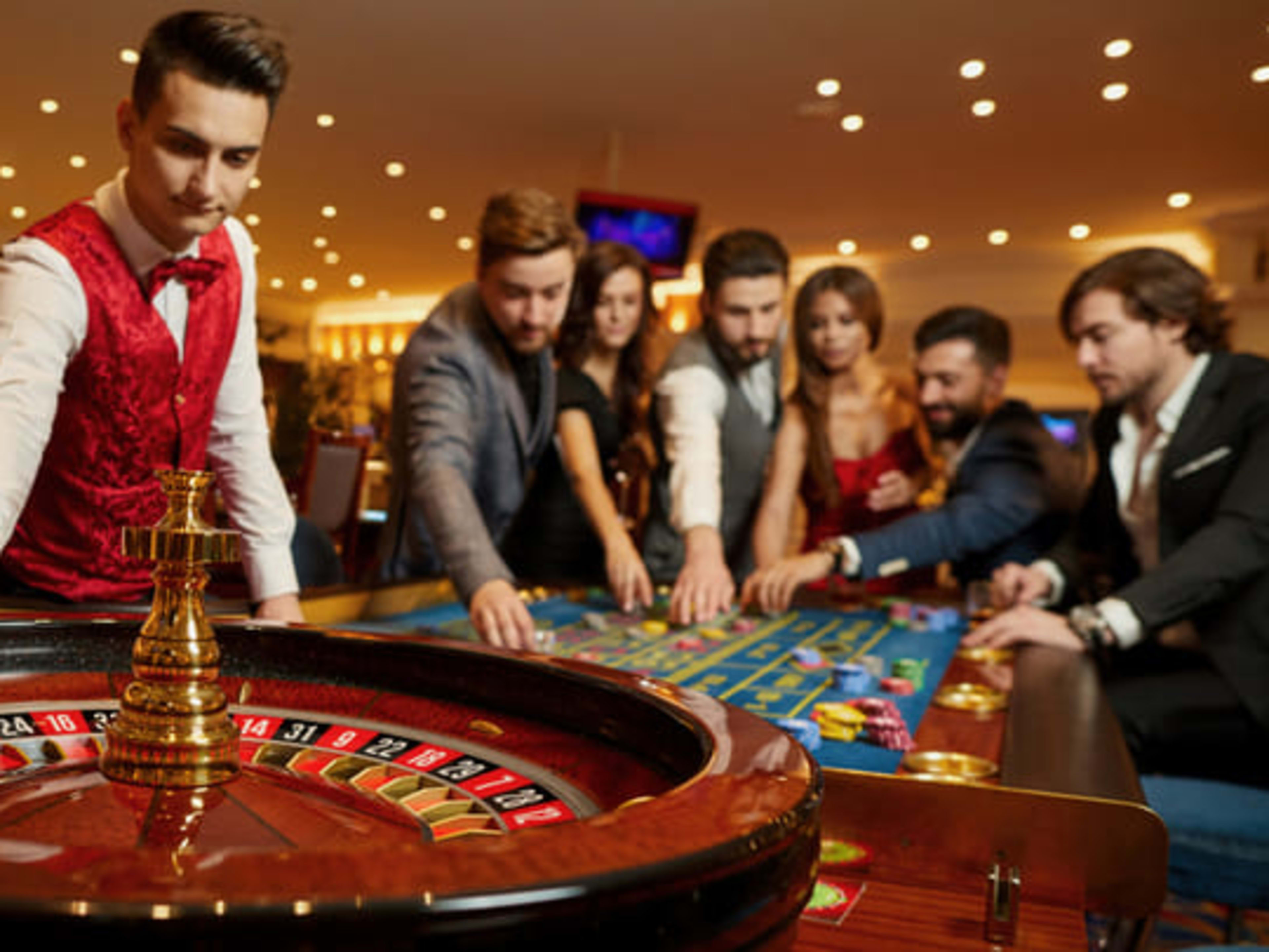 Casino croupier taking bets at the roulette wheel