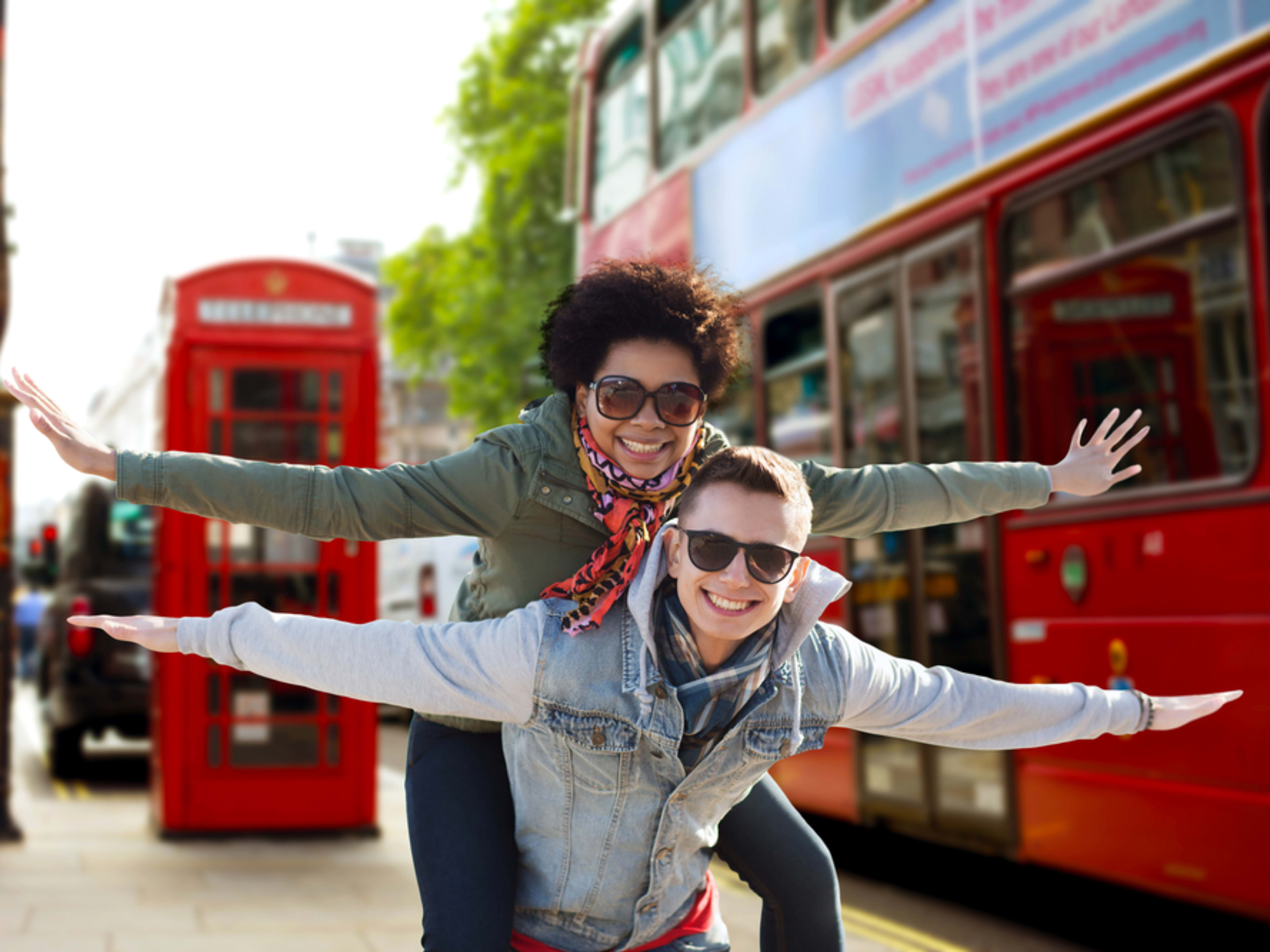 Friends posing with arms out like aeroplane wings in Central London