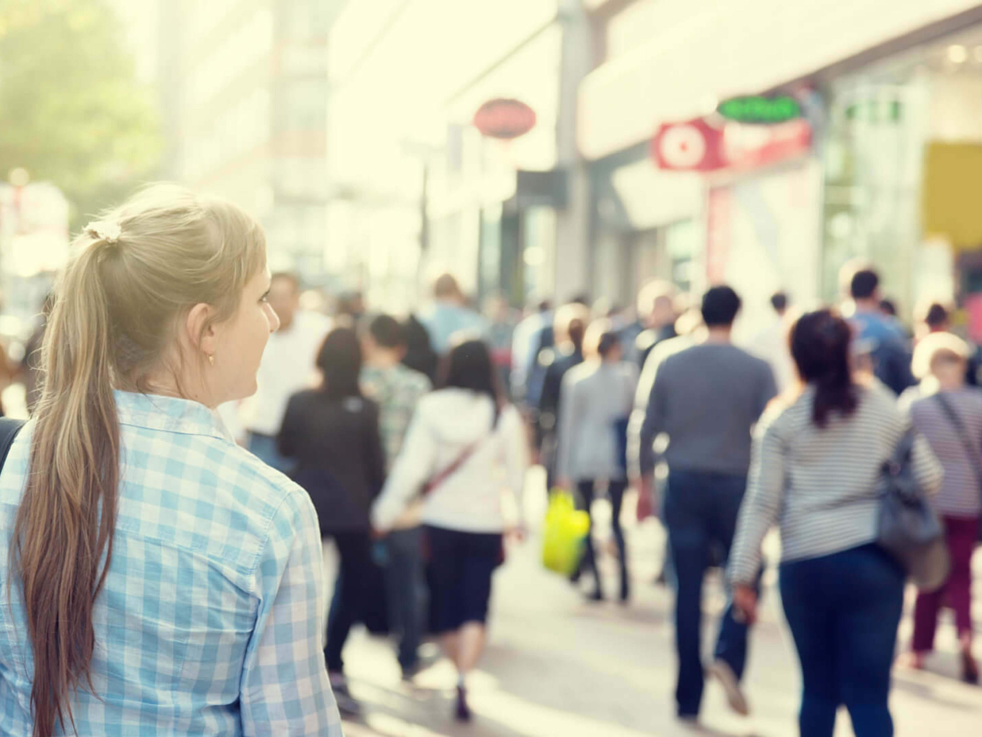 A woman walks alone through a busy London street
