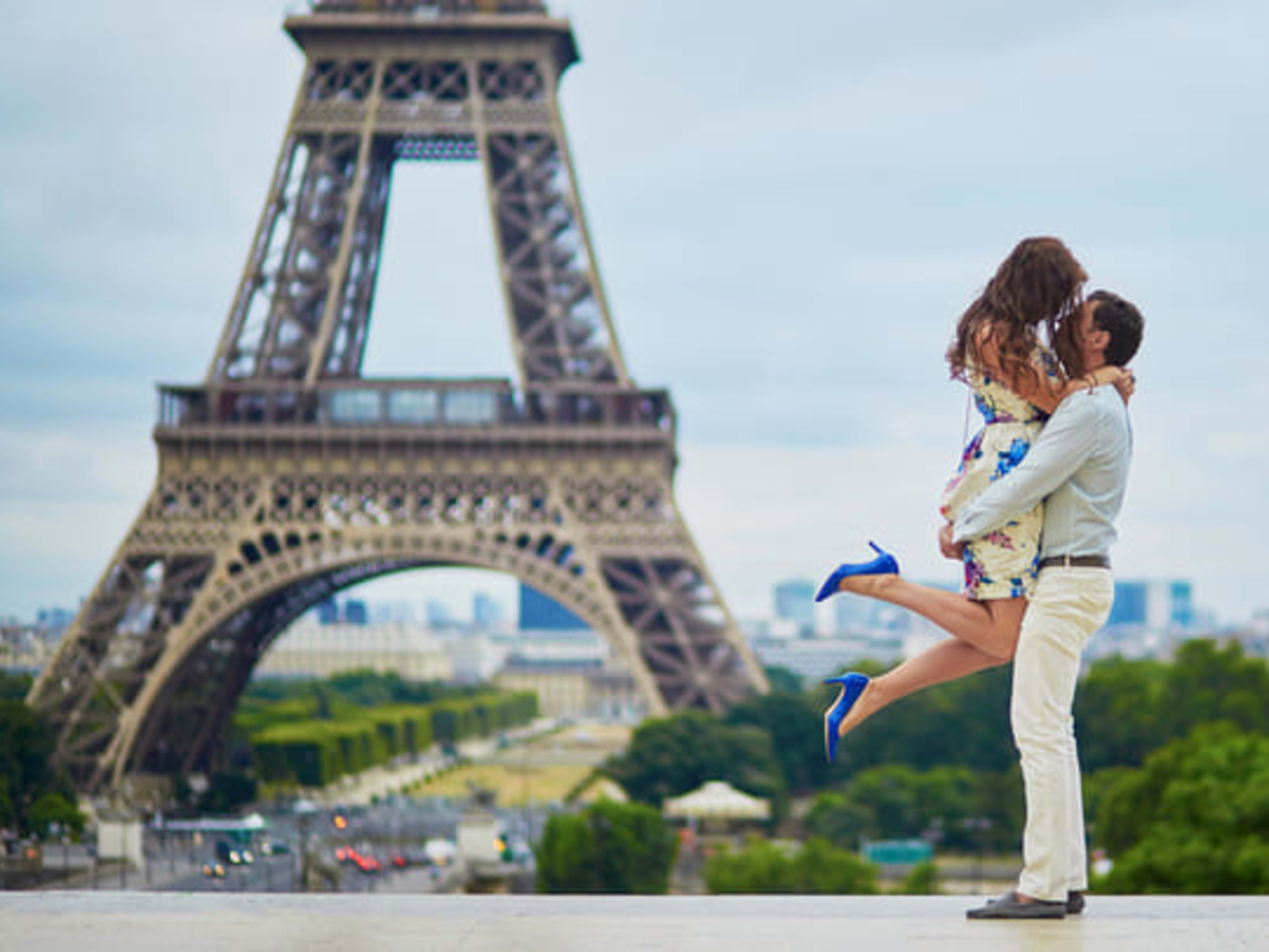 A couple embrace in front of the Eiffel Tower in Paris