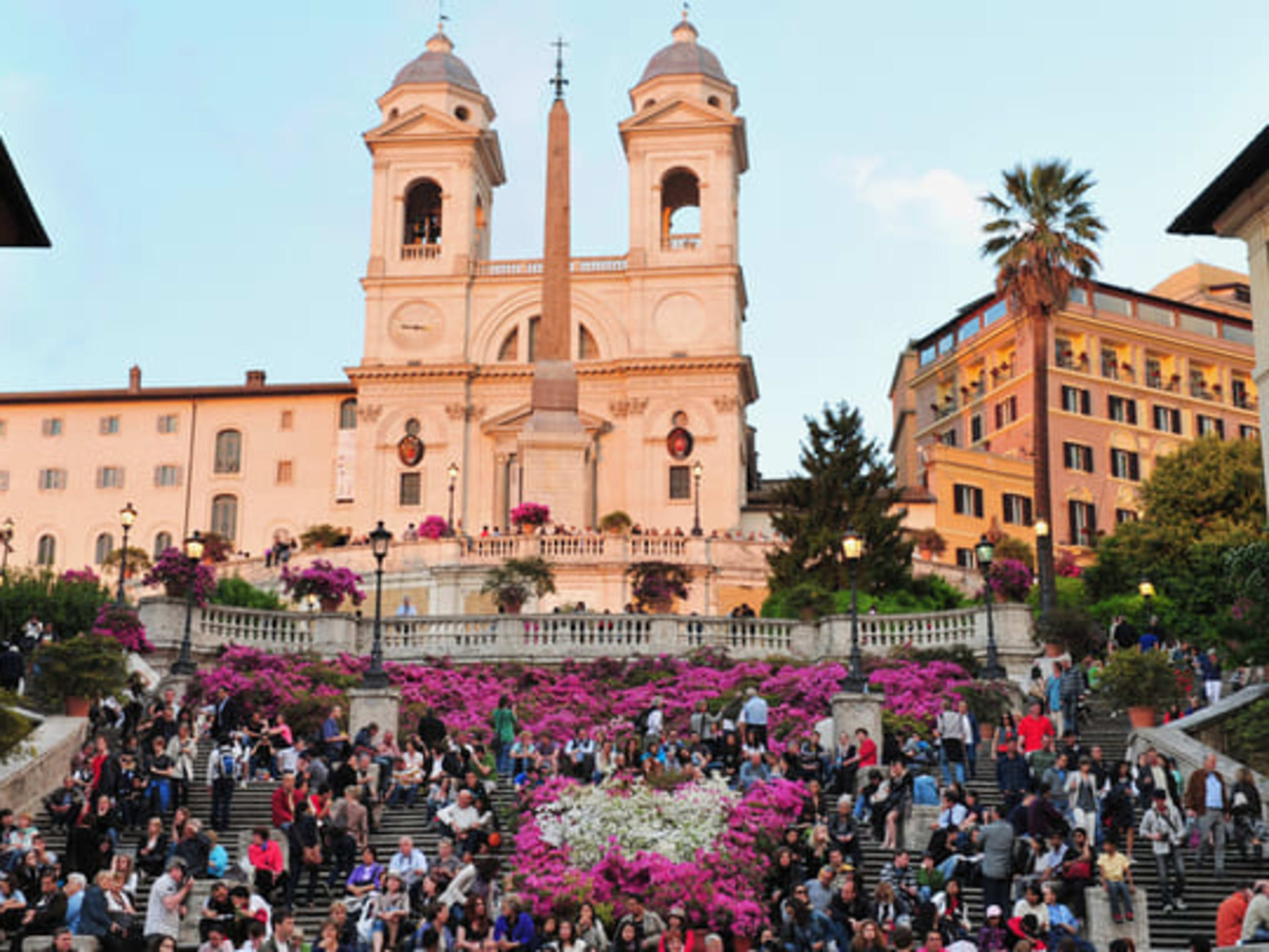 Couple descending the Spanish Steps in Rome, with the Trinità dei Monti church behind them