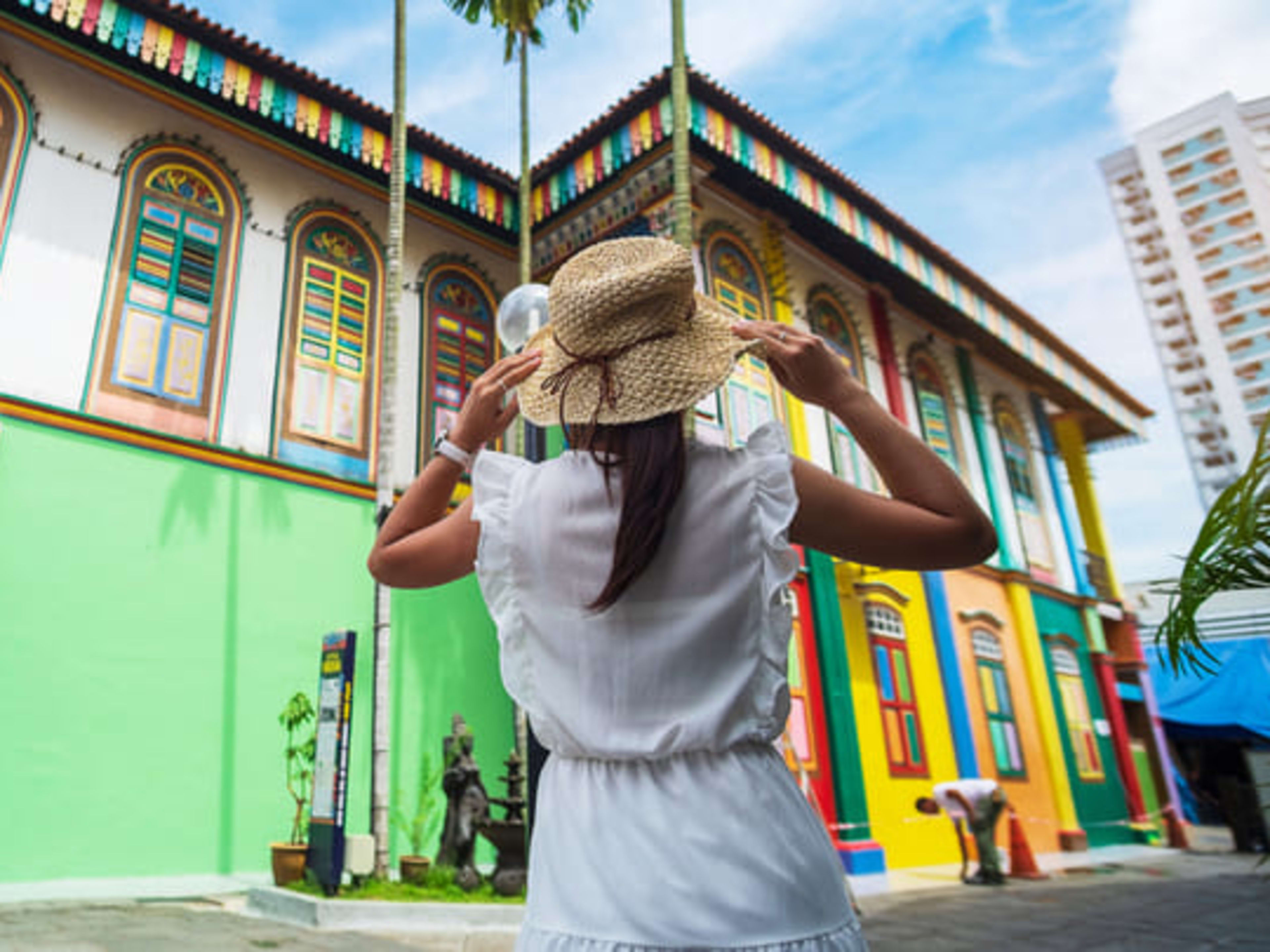 Woman exploring colorful buildings in Singapore's Little India neighborhood