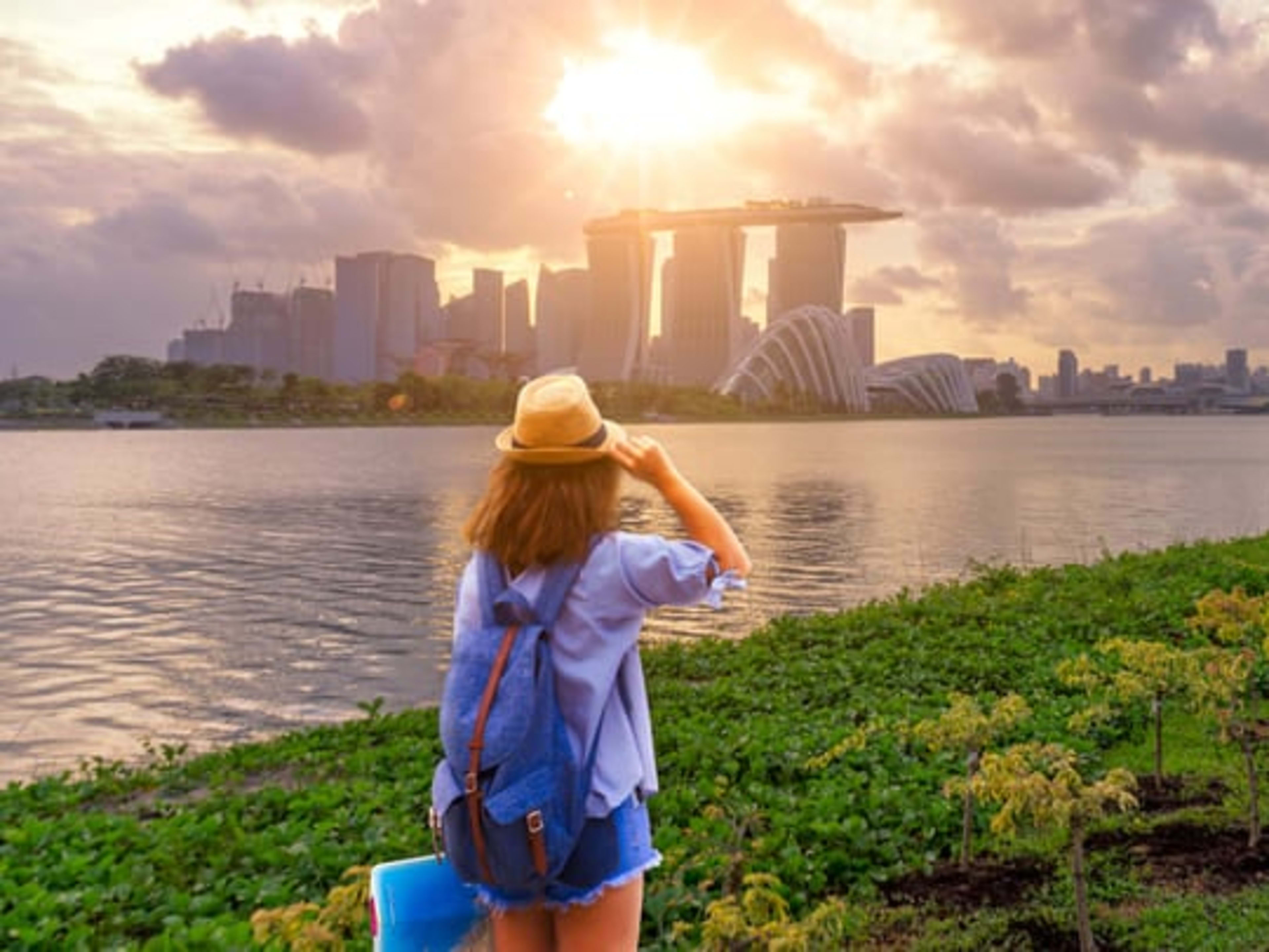 Woman watching the sun set over Marina Bay Sands in Singapore.