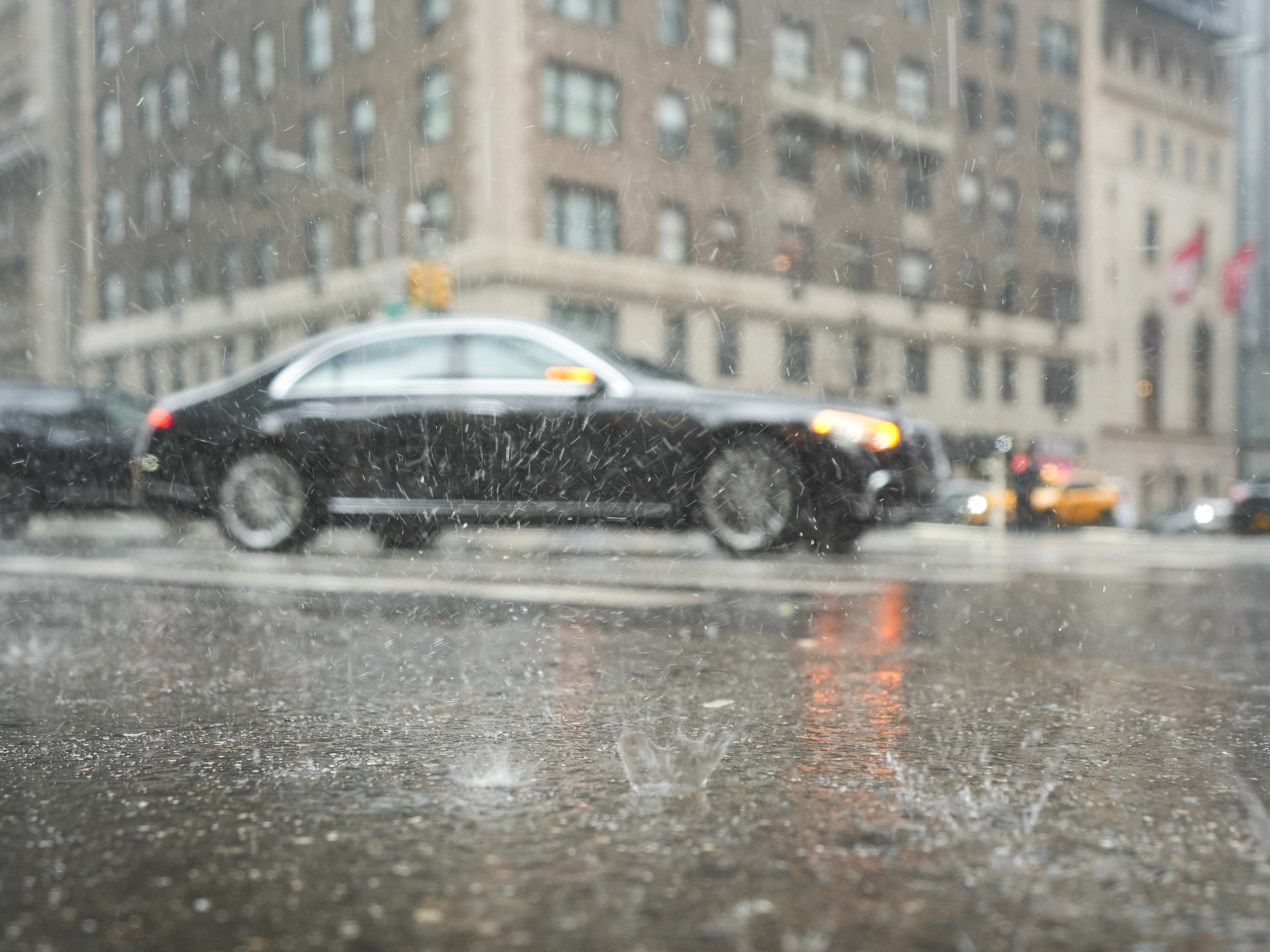 rainy street in NYC with cars driving by
