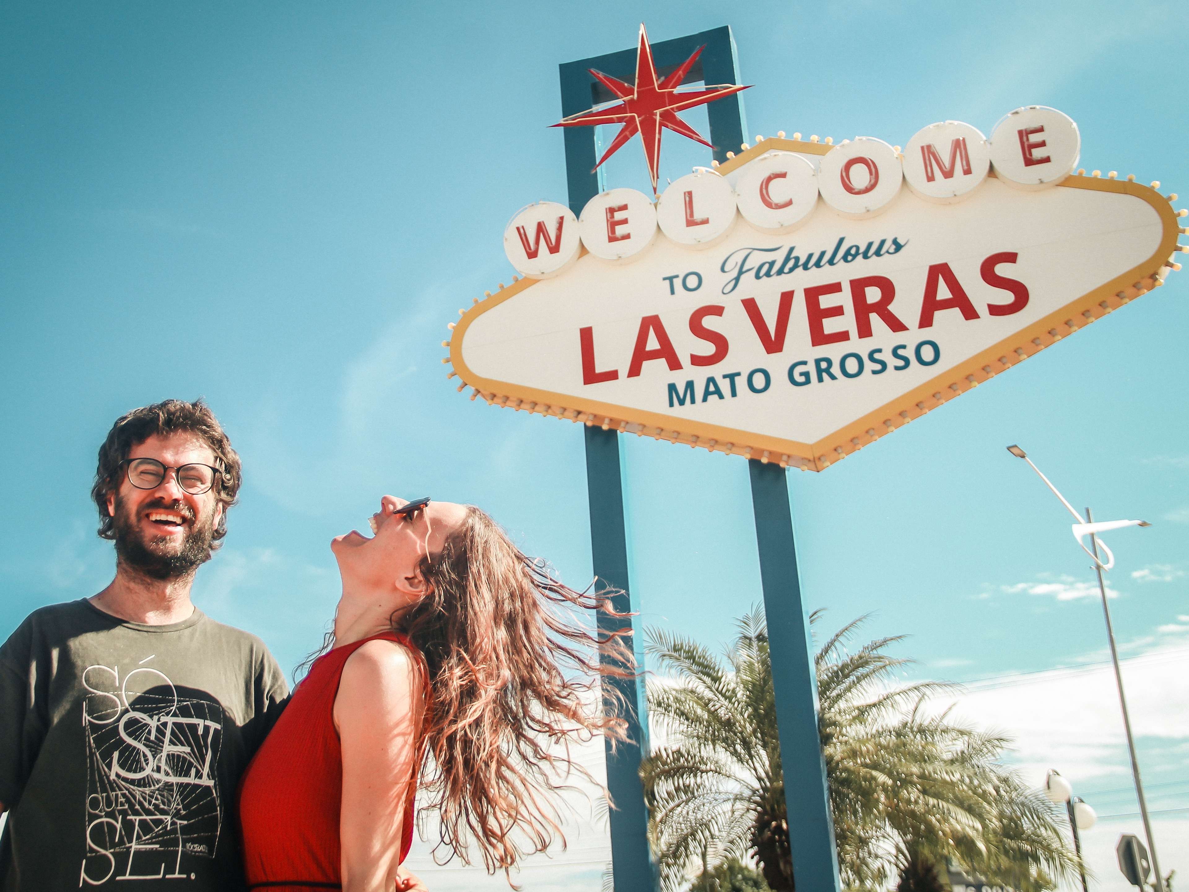 couple laughing in front of the Las Vegas sign