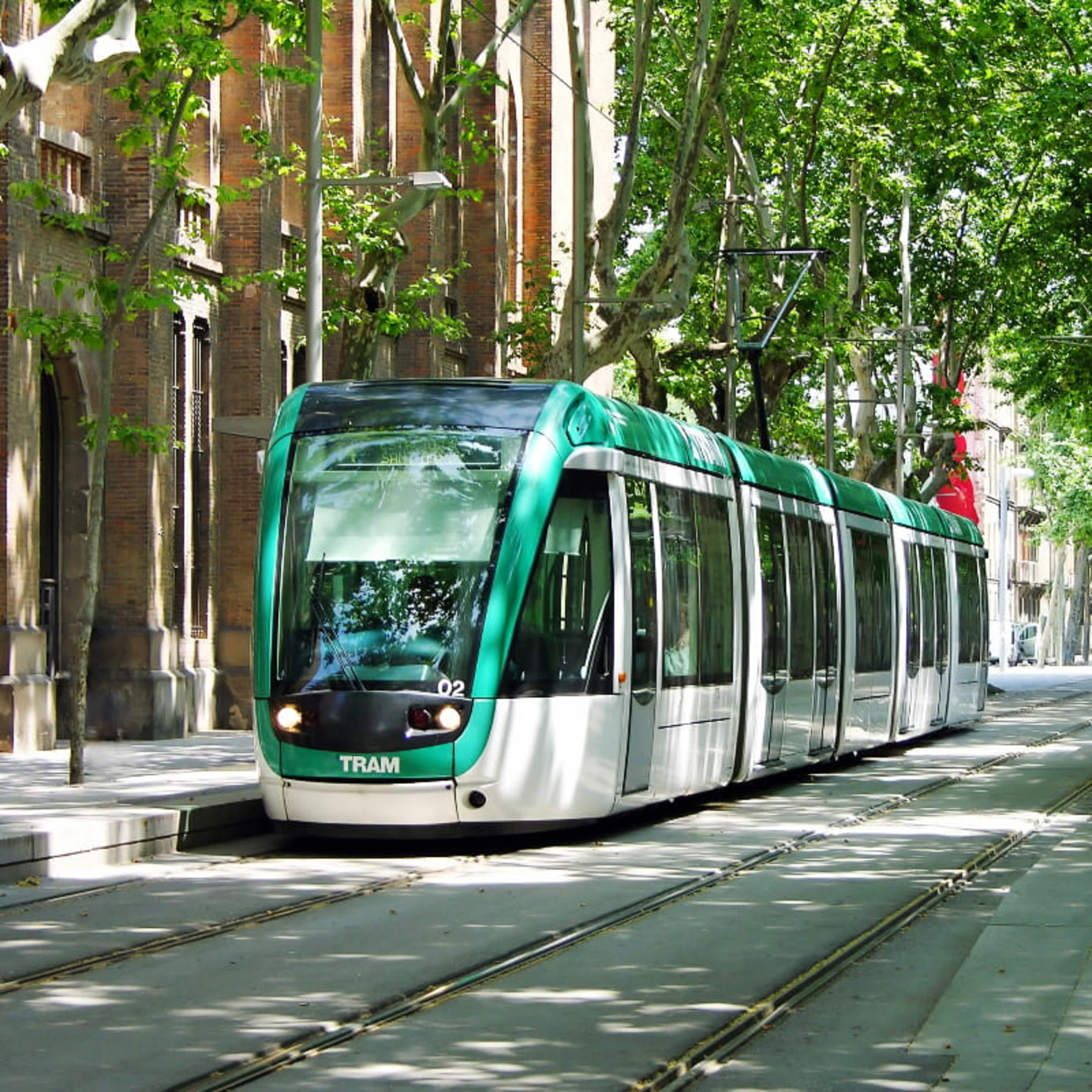A modern tram driving through the streets of Barcelona