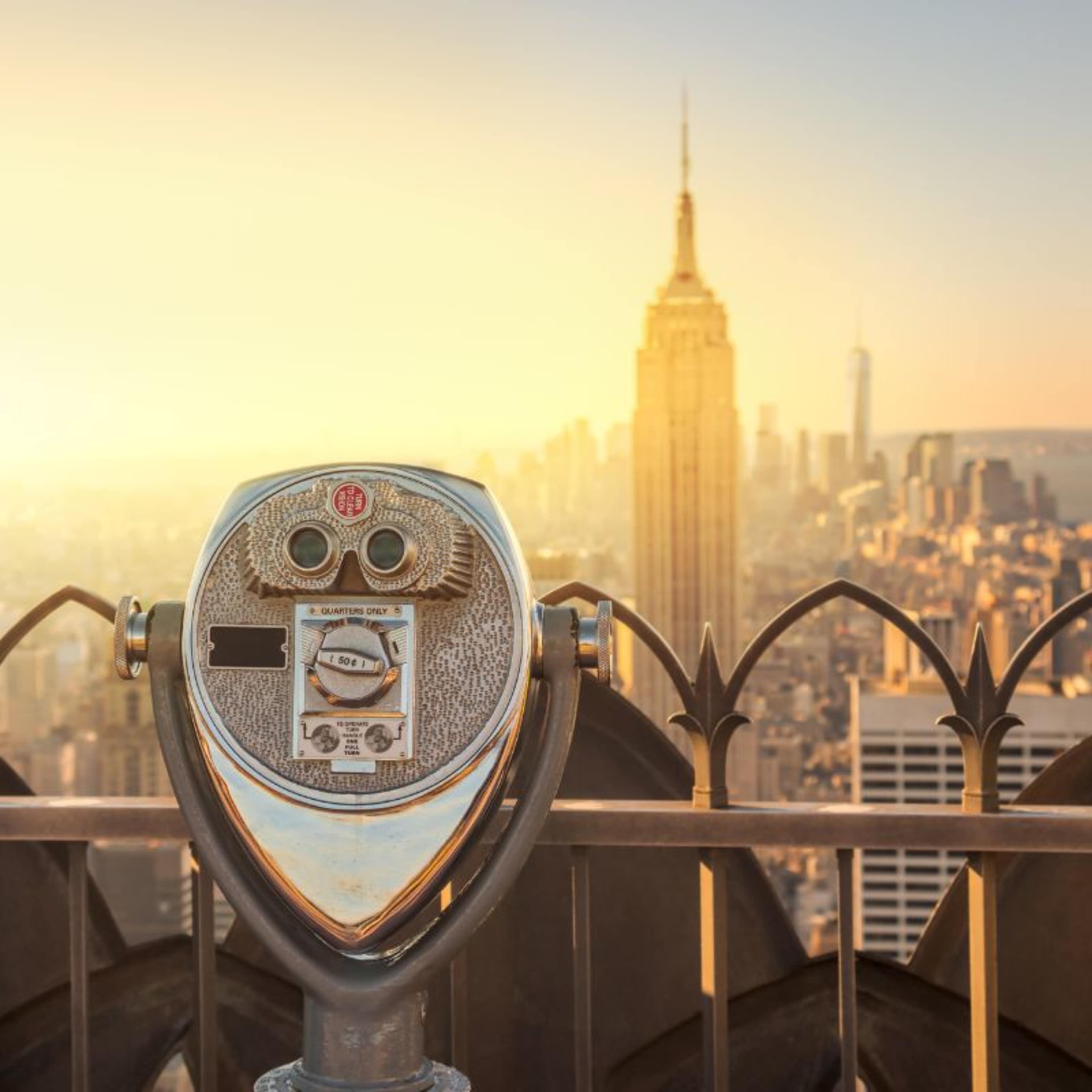 Close up of viewing station at TOTR with Empire state building glowing gold in distance