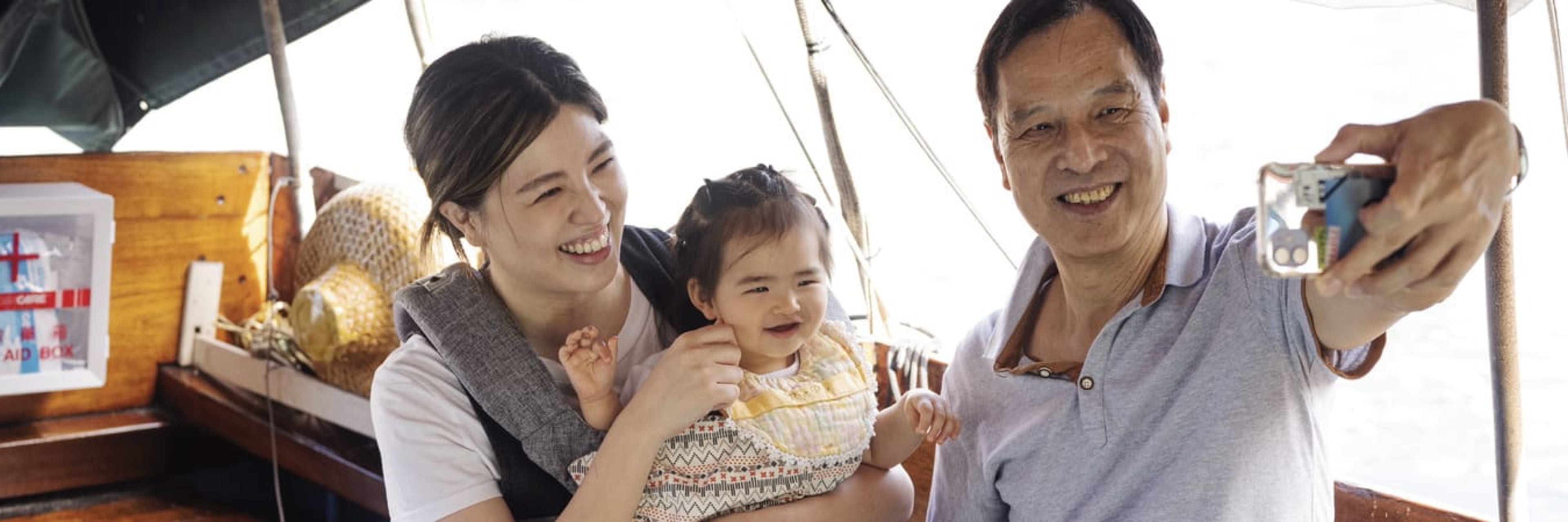 Family taking a selfie on board a sampan boat tour.