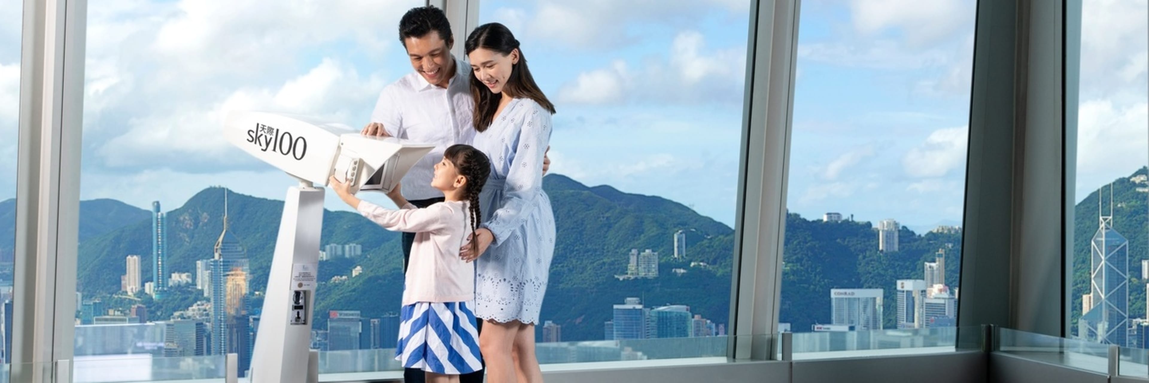 Family using a viewfinder at the Sky100 Hong Kong Observation Deck.
