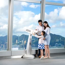 Family using a viewfinder at the Sky100 Hong Kong Observation Deck.