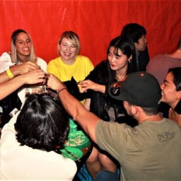 A group of young revelers toasting with shot glasses on a Seoul pub crawl