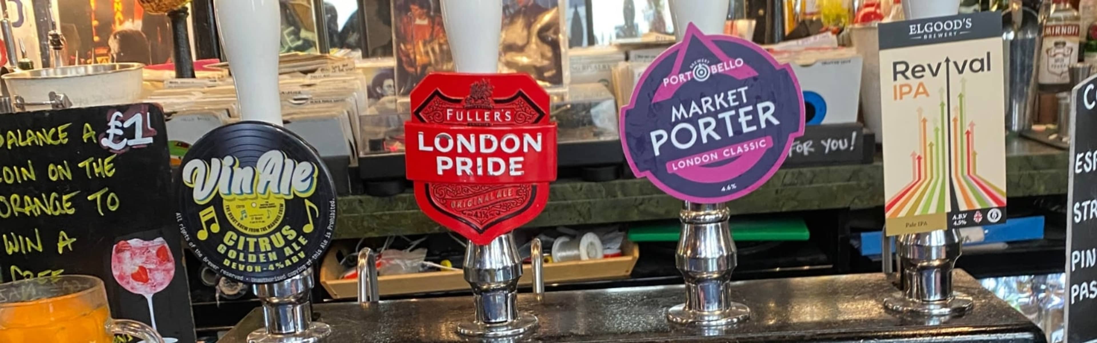 Ale pumps along a bar in a London pub.