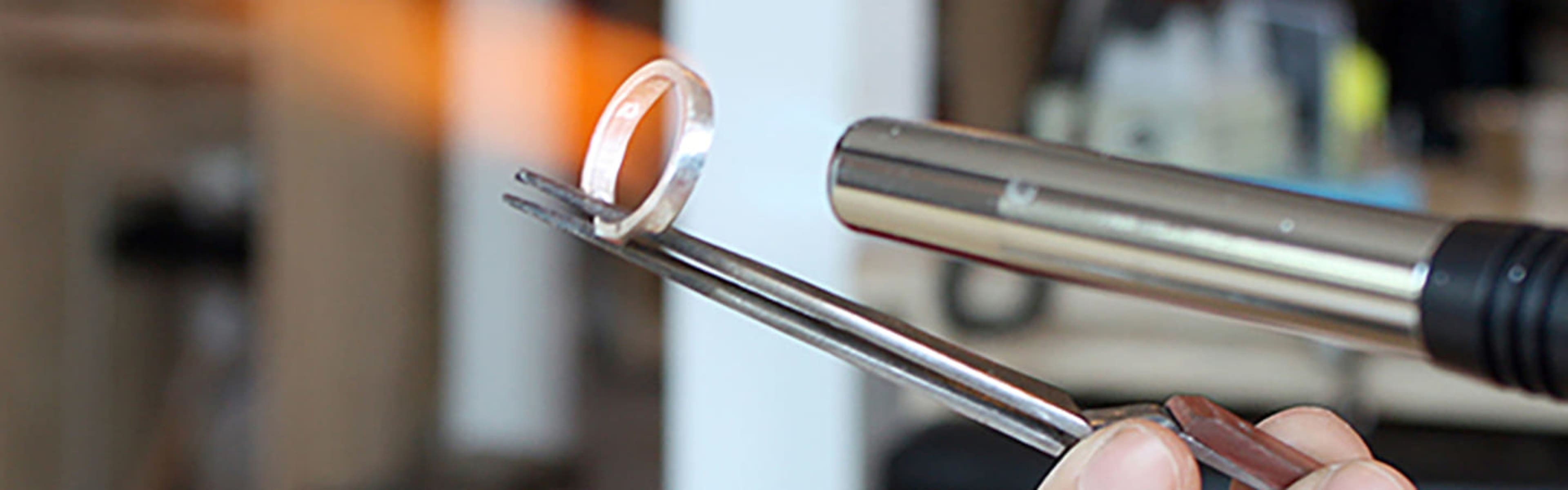 Ring-maker applying heat to a silver ring