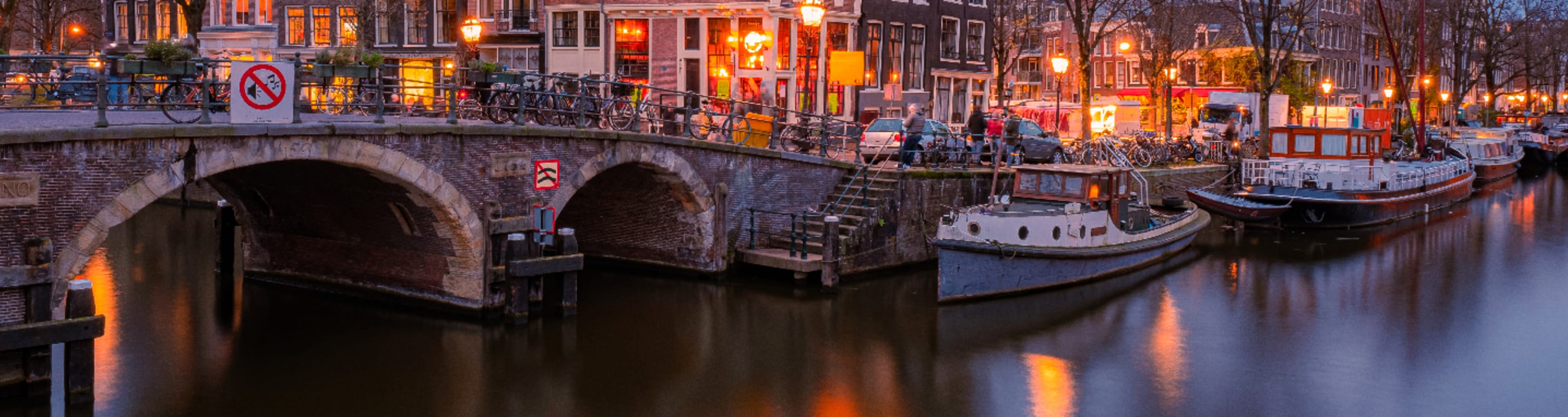 Amsterdam canal houses and bridge reflected in a still canal