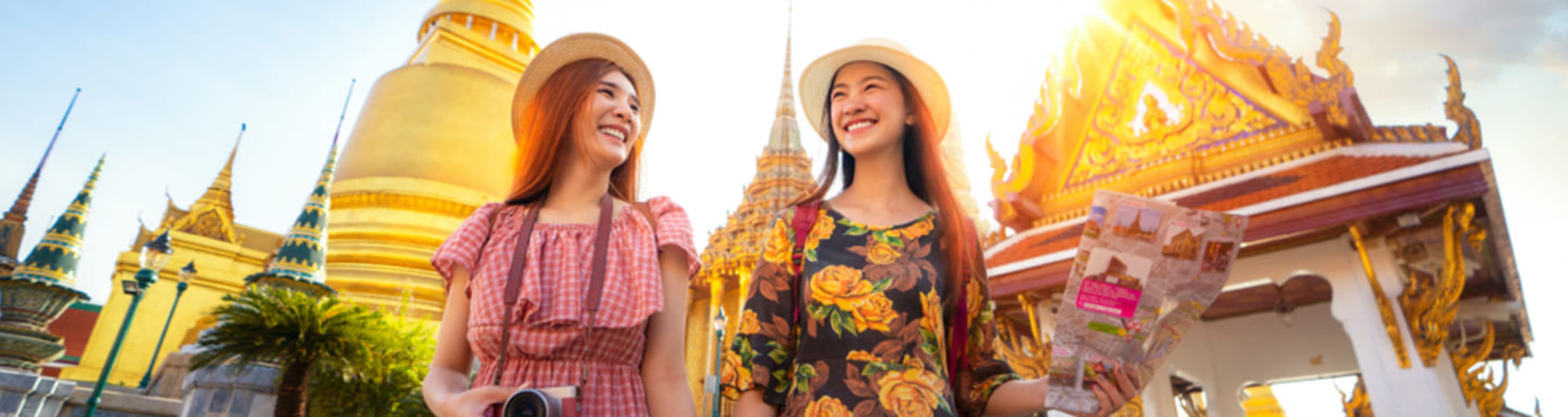 Two women exploring the Grand Palace complex in Bangkok.