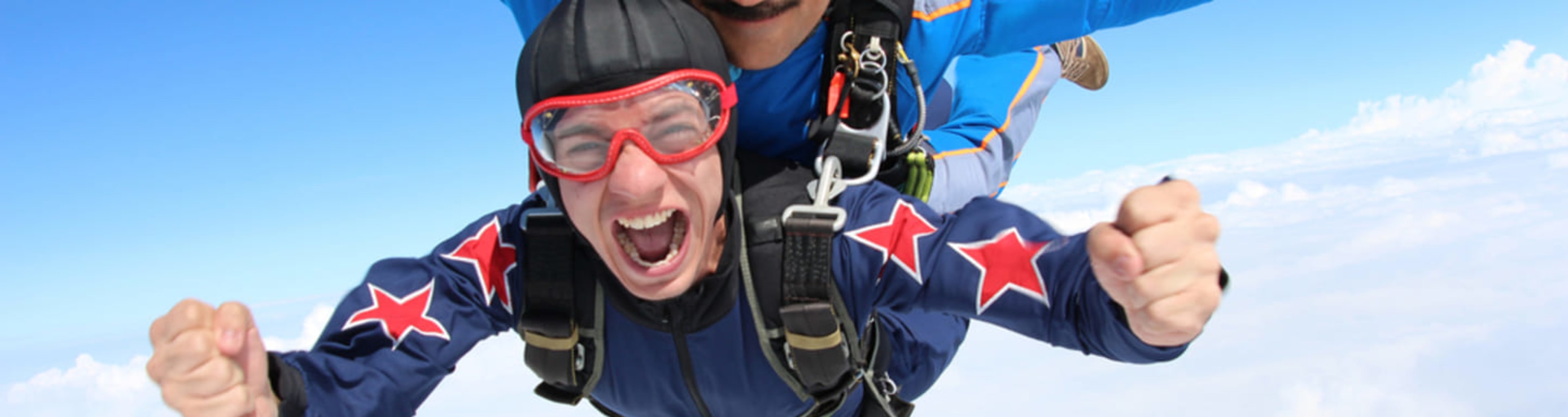 A skydiver cheering happily in freefall.