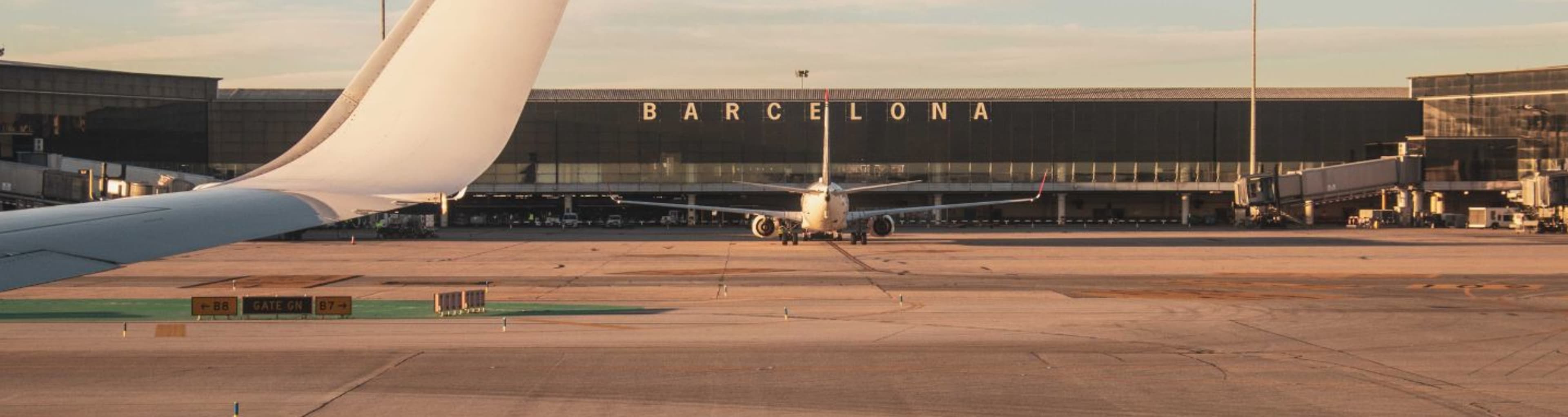 Panorama shot of Barcelona airport, with sign and part of an aeroplane tail