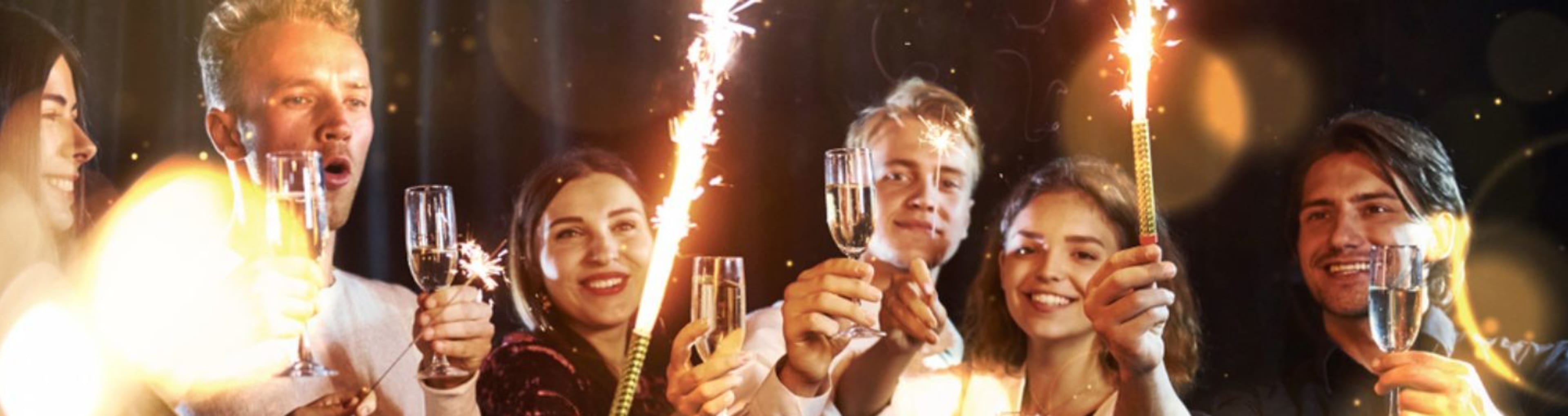 Group of friends raising a New Year toast, with champagne and sparklers