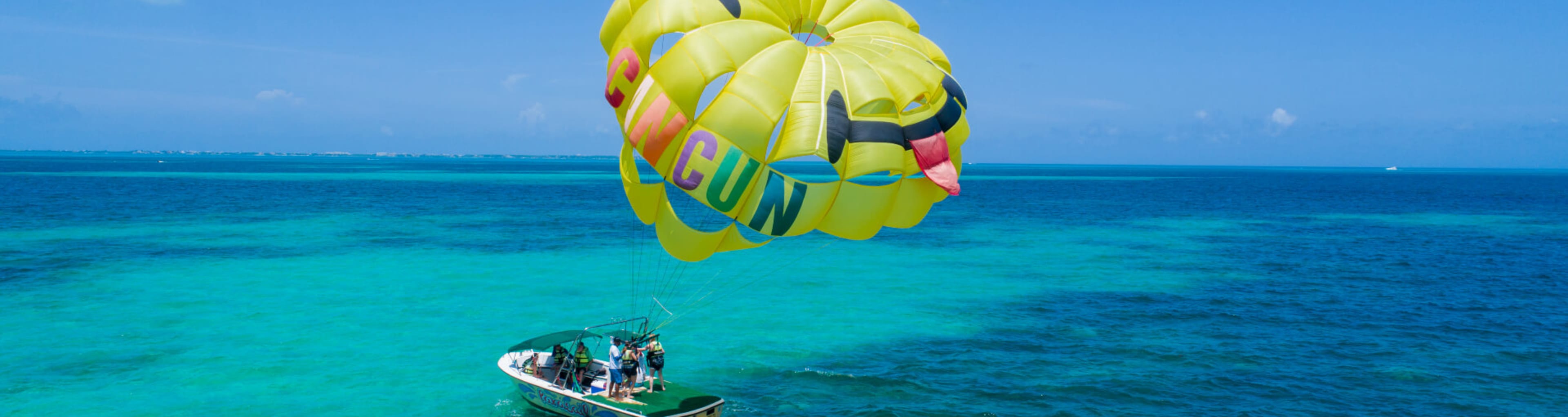 Speedboat with parasail inflated above it in Cancun